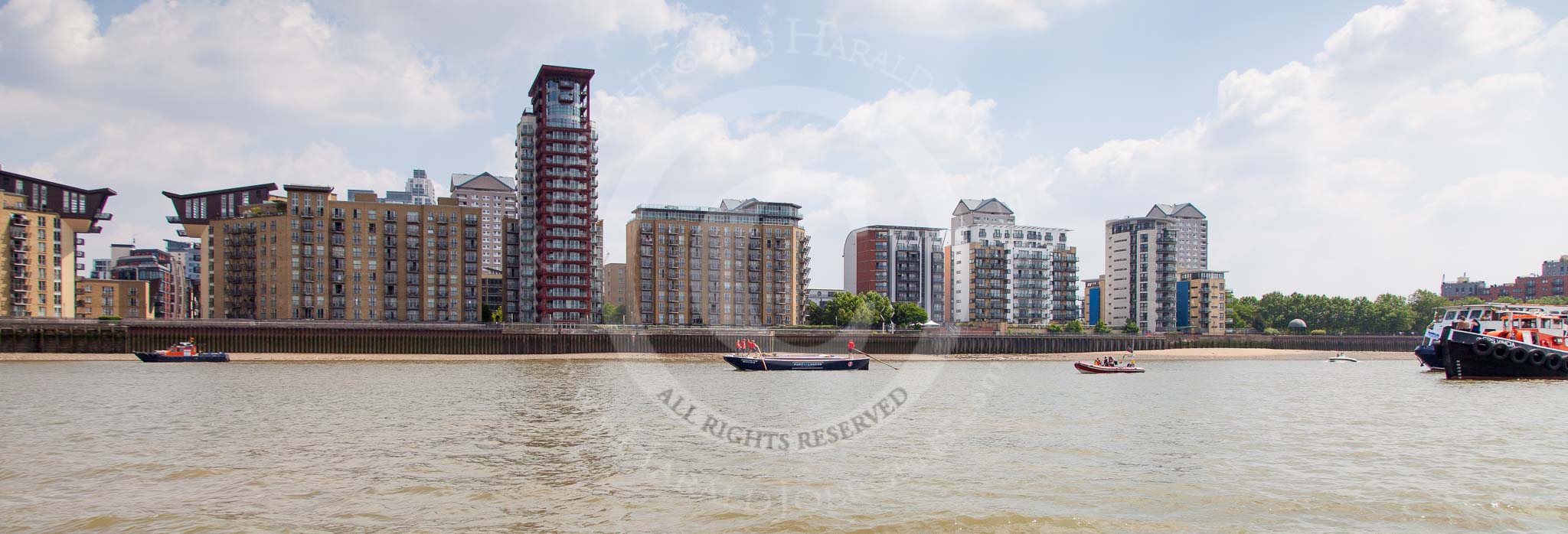 Photo 1307131306045D23956HaraldJoergens TOW River Thames Barge Driving Race 2013: Barge "Blackwall", by the Port of London Authority, in front of builings at the Thames Path. On the very right the flotilla of pleasure boats following the race leader "Blackwall"..
River Thames between Greenwich and Westminster,
London,
United Kingdom,
on 13 July 2013 at 13:06, image #271