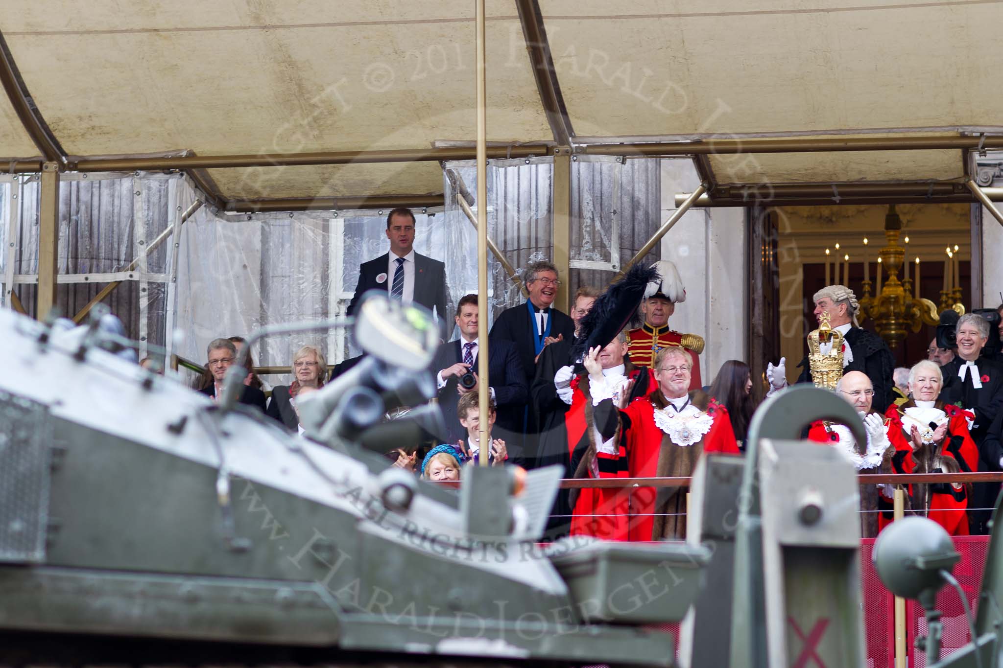 The Lord Mayor's Show 2011: The new Lord Mayor, David Wootton, waiving his tricorne hat on the balcony of Mansion House, as an armored personal carrier from 151 (London) Transport Regiment (V) passes by..
Opposite Mansion House, City of London,
London,
-,
United Kingdom,
on 12 November 2011 at 11:30, image #313