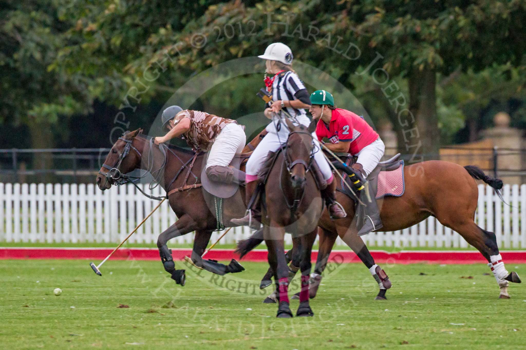 DBPC Polo in the Park 2012: Royal Artillery #4, Alex Vent, against DBPC #2, Captain William Mawby, passing behind umpire Barbara Zingg..
Dallas Burston Polo Club,
Stoneythorpe Estate,
Southam,
Warwickshire,
United Kingdom,
on 16 September 2012 at 19:01, image #344
