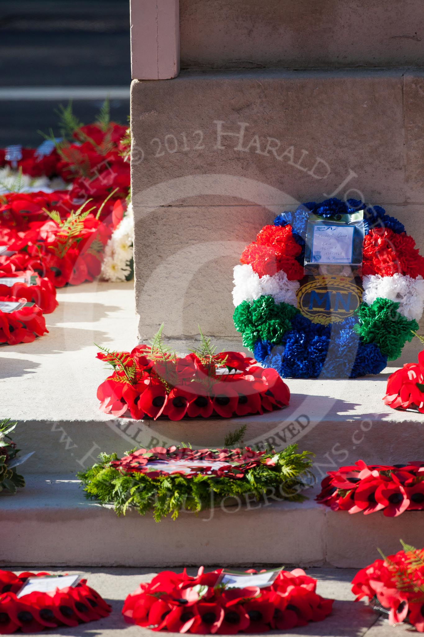 Remembrance Sunday 2012 Cenotaph March Past: "Herbert Quine + Crew 1914-1918/1939-1945/In Remembrance" - blue, red, white, green and blue wreath at the southern side of the Cenotaph..
Whitehall, Cenotaph,
London SW1,

United Kingdom,
on 11 November 2012 at 12:18, image #1782