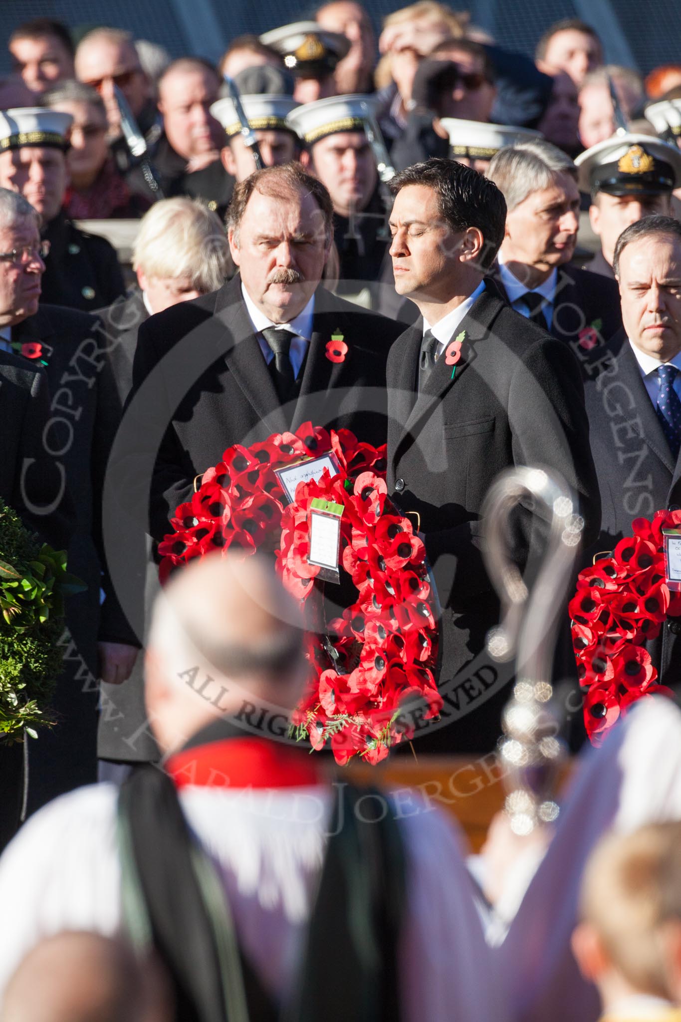 Ed Miliband, as Leader of the Opposition, about to lay a wreath at the Cenotaph. In the foreground, and out of focus, the Bishop of London.
