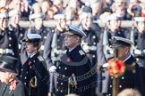 The golden cross with the poppies carried by the cross bearer, out of focus, and HRH The Princess Royal, HRH The Duke of York and HRH The Duke of Edinburgh.