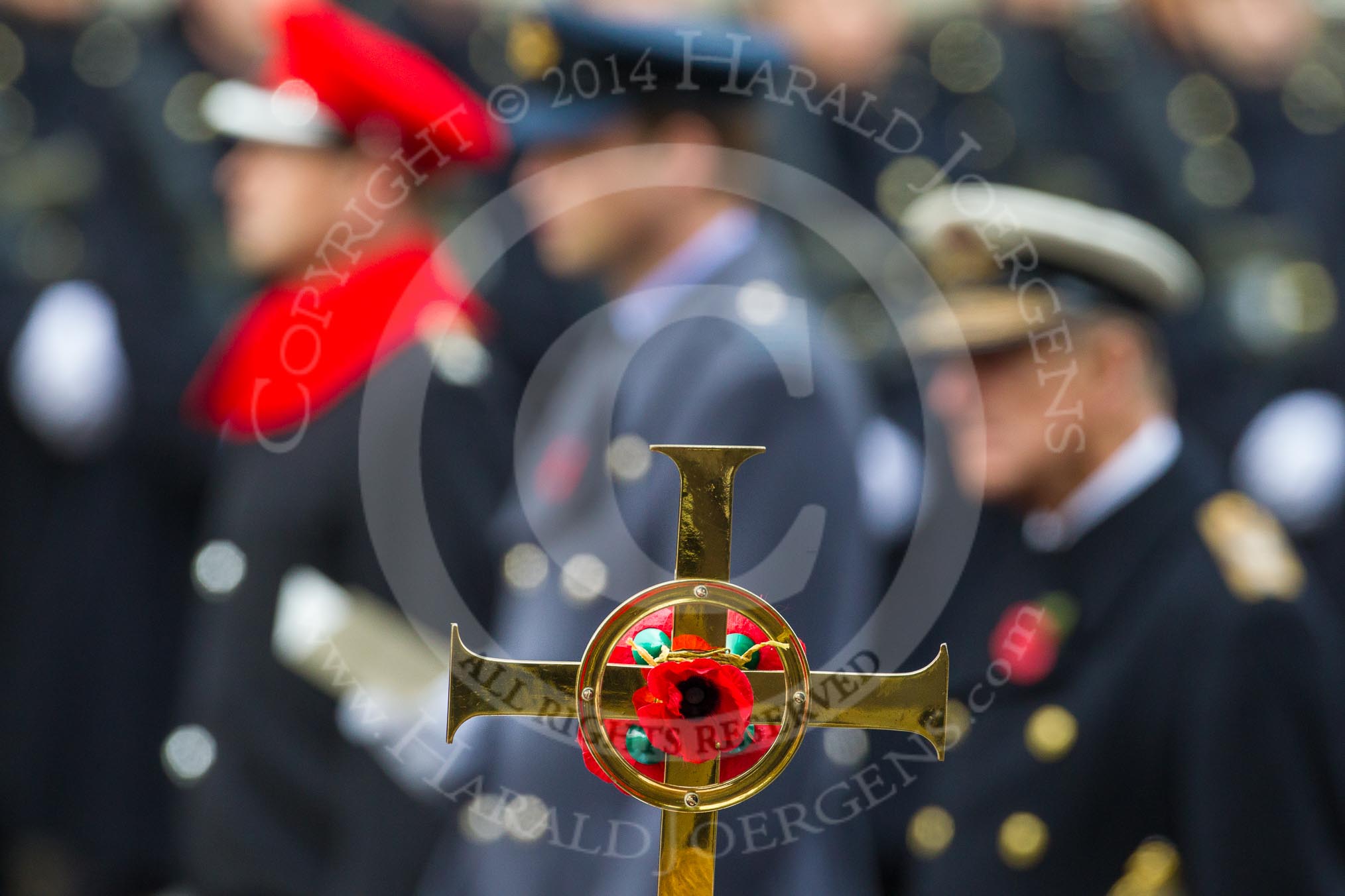 Remembrance Sunday at the Cenotaph in London 2014: The golden cross with the poppies, behind, and out of focus, the Duke of Edinburgh, the Duke of Cambridge, and the Duke of York.
Press stand opposite the Foreign Office building, Whitehall, London SW1,
London,
Greater London,
United Kingdom,
on 09 November 2014 at 11:16, image #266