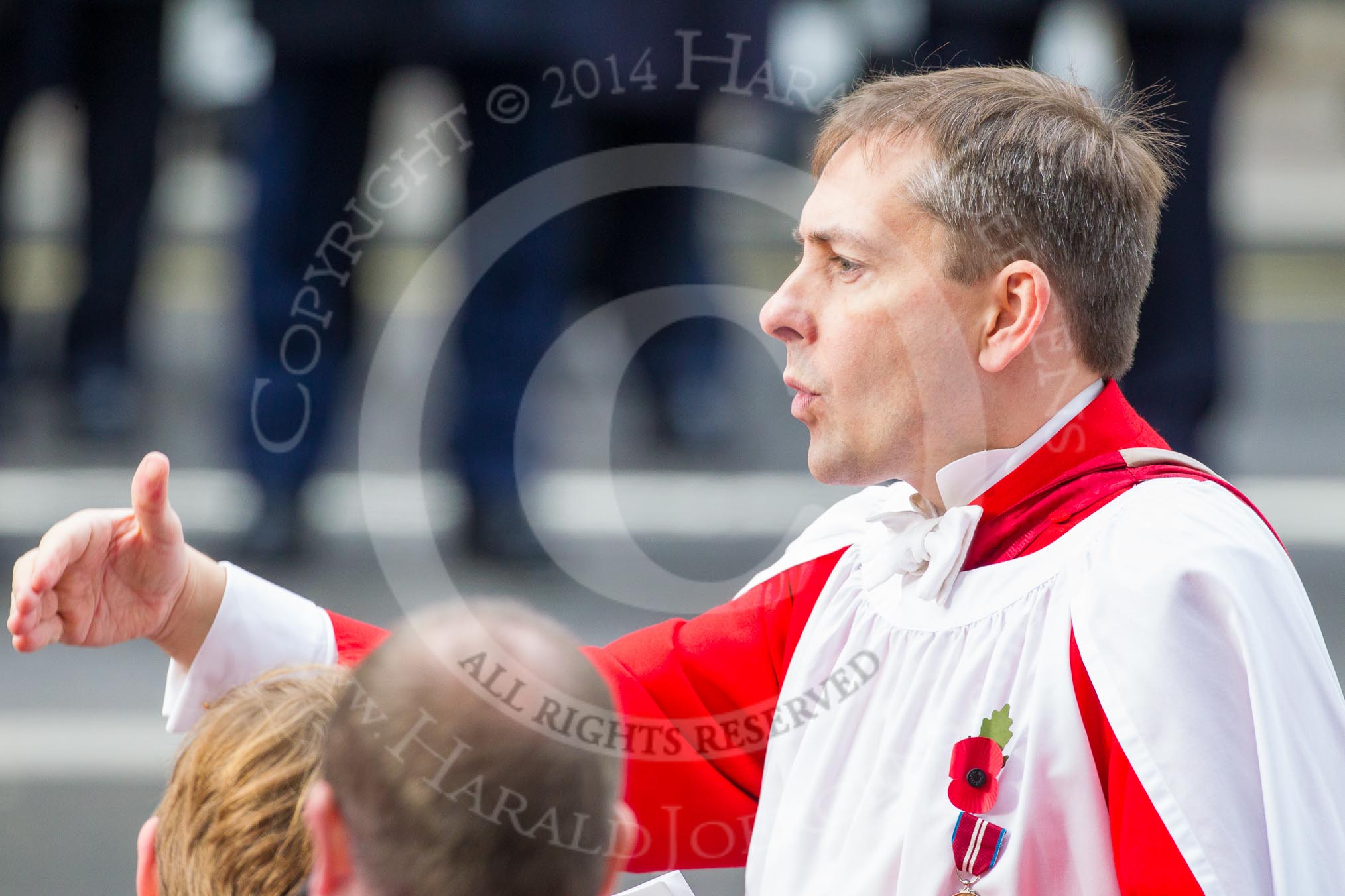 Remembrance Sunday at the Cenotaph in London 2014: Hugh Williams, Director of Music of Her Majesty's Chapel Royal at St James's Palace, conducting the choir during the service.
Press stand opposite the Foreign Office building, Whitehall, London SW1,
London,
Greater London,
United Kingdom,
on 09 November 2014 at 11:16, image #272