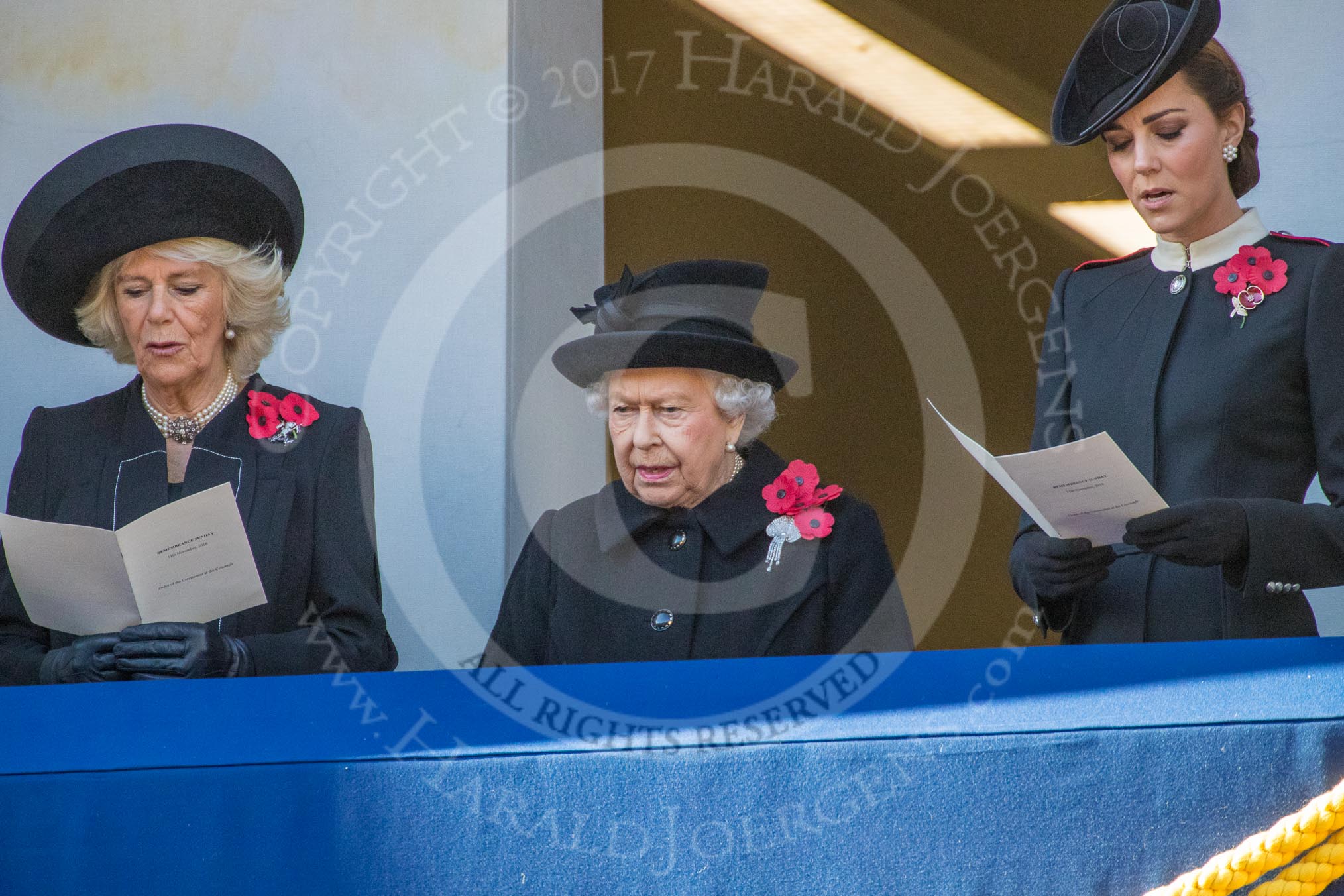 Photo #363 (1811111118291X21412HaraldJoergens) HRH The Duchess of Cornwall (Camilla), Her Majesty The Queen, and HRH The Duchess of Cambridge (Kate), singing, on the balcony of the Foreign and Commonwealth Office during the Remembrance Sunday Cenotaph Ceremony 2018 at Horse Guards Parade, Westminster, London, 11 November 2018, 11:18.