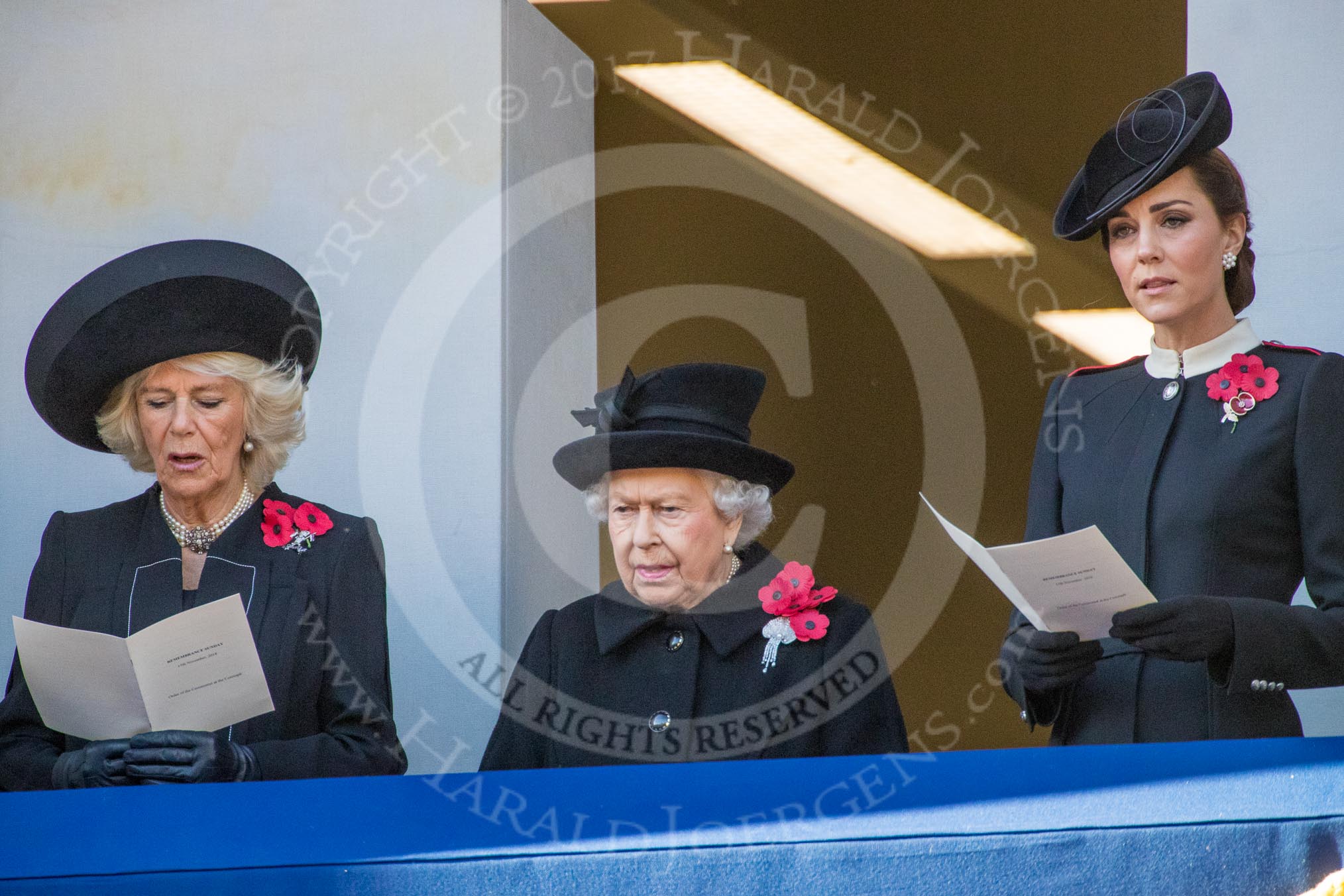 HRH The Duchess of Cornwall (Camilla), Her Majesty The Queen, and HRH The Duchess of Cambridge (Kate), singing, on the balcony of the Foreign and Commonwealth Office during the Remembrance Sunday Cenotaph Ceremony 2018 at Horse Guards Parade, Westminster, London, 11 November 2018, 11:18.