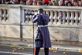 An army photographer shooting the service detachments arriving on Whitehall before the Remembrance Sunday Cenotaph Ceremony 2018 at Horse Guards Parade, Westminster, London, 11 November 2018, 10:23.