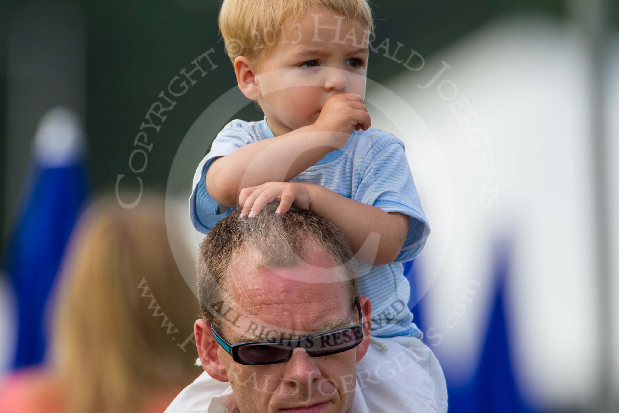Henley Royal Regatta 2013, Saturday: Watching the race between the German and the British coxed four for the Britannia Challenge Cup, a young man on his father's shoulders. Image #72, 06 July 2013 10:01 River Thames, Henley on Thames, UK