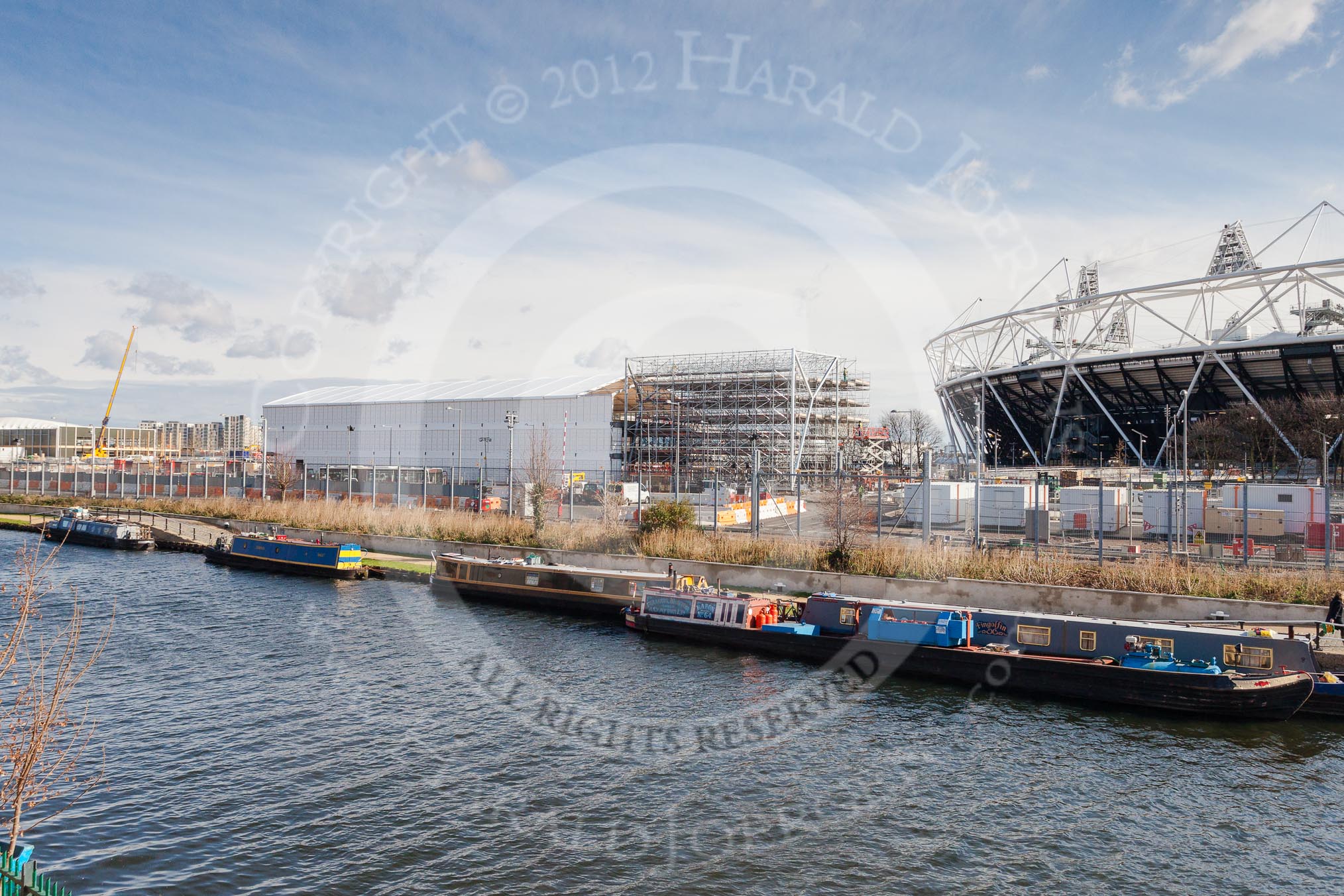 The Boat Race season 2012 - Crew Announcement and Weigh In: The River Lee seen from Forman's Fish Island. Behind the moored narrowboats the Olympic Park, with the Olympic Stadium on the right..
Forman's Fish Island,
London E3,

United Kingdom,
on 05 March 2012 at 10:43, image #56