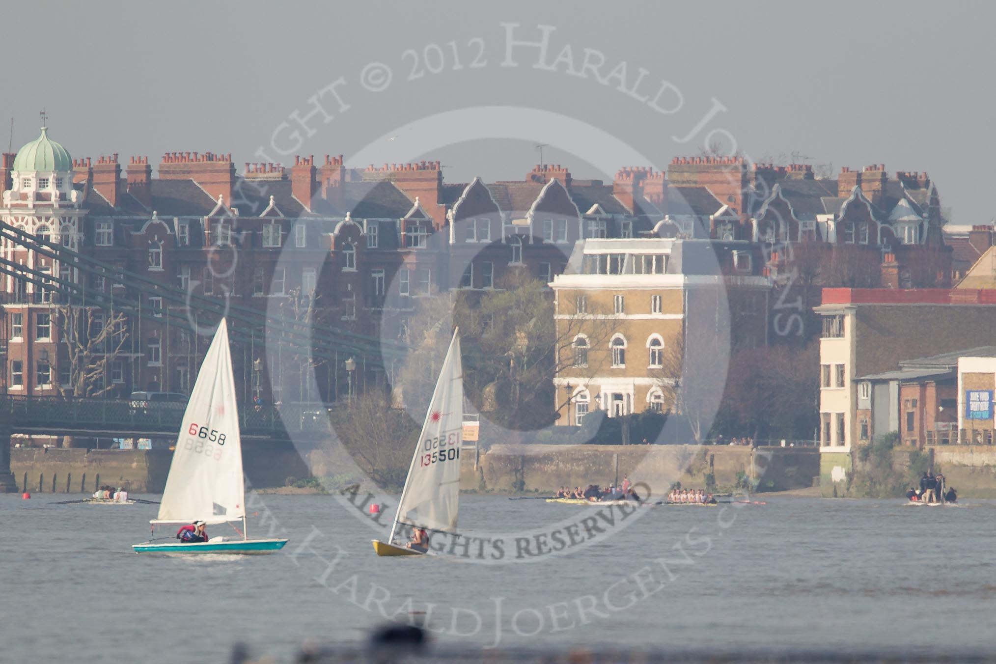 The Boat Race season 2012 - fixture OUBC vs Leander: Approaching Hammersmith Bridge, the OUBC Blue Boat on the right, Leander on the left, both followed by umpire Richard Phelps. The distance from the camera is now around 2500m, and the slight distortions are caused by warm, turbulent air..




on 24 March 2012 at 14:34, image #148