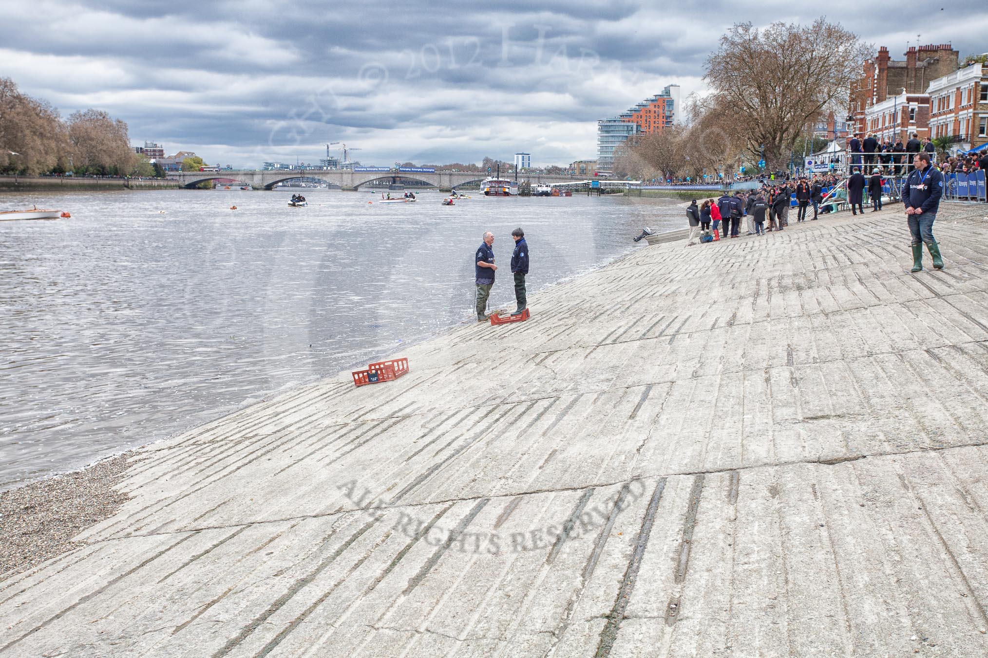 Photo 1204071323135D21841HaraldJoergensE98 The Boat Race 2012: Setting the scene for the 2012 Boat Race: Putney Embankment, looking towards Putney Bridge. The blue Xchanging barriers on the right have been opened so the boats can be moved on the Thames..
on 07 April 2012 at 13:23, image #125