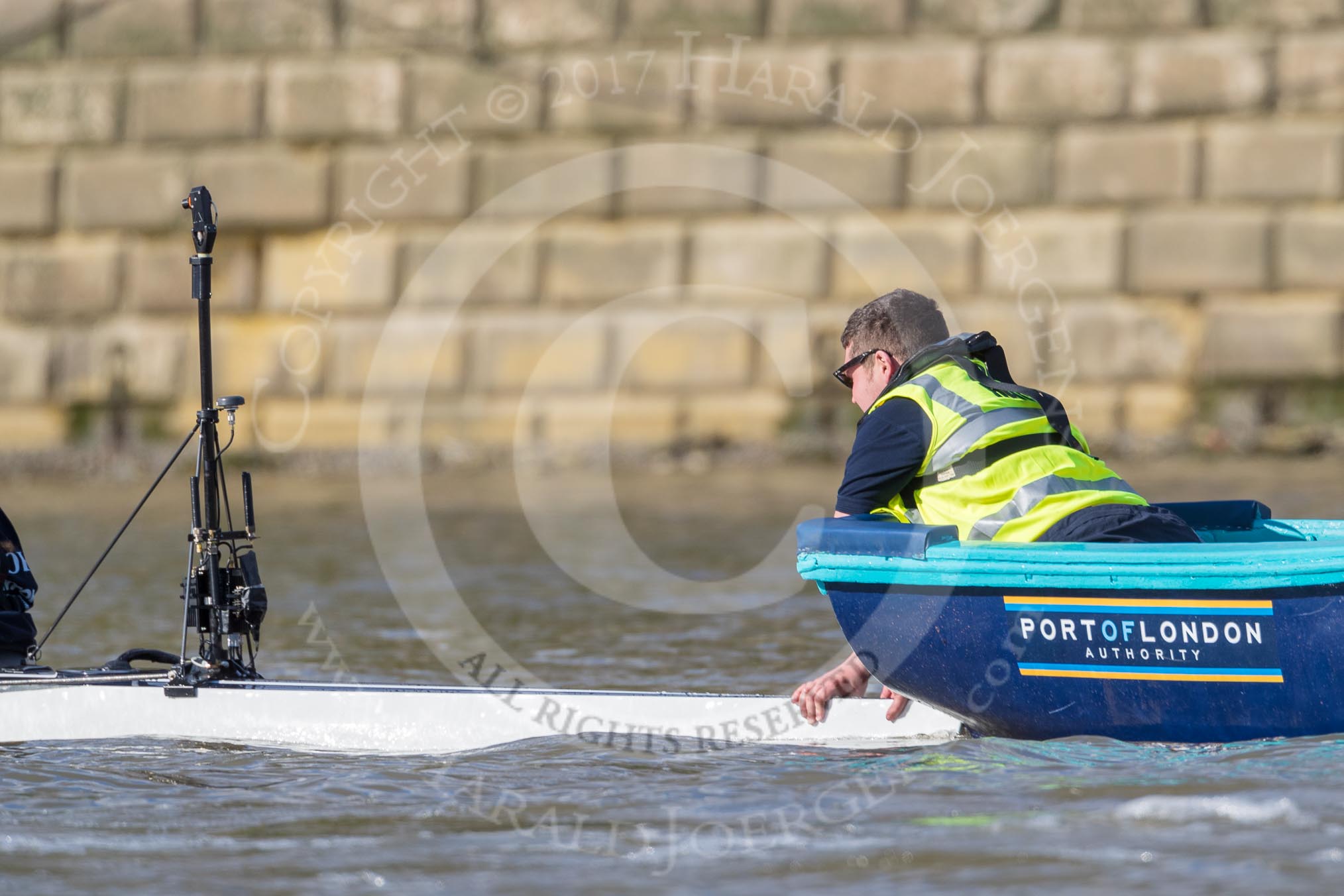 The Boat Race season 2017 -  The Cancer Research Women's Boat Race: A gentleman in the Port of London Authority stake boat holding the CUWBC boat before the start of the race.
River Thames between Putney Bridge and Mortlake,
London SW15,

United Kingdom,
on 02 April 2017 at 16:30, image #115