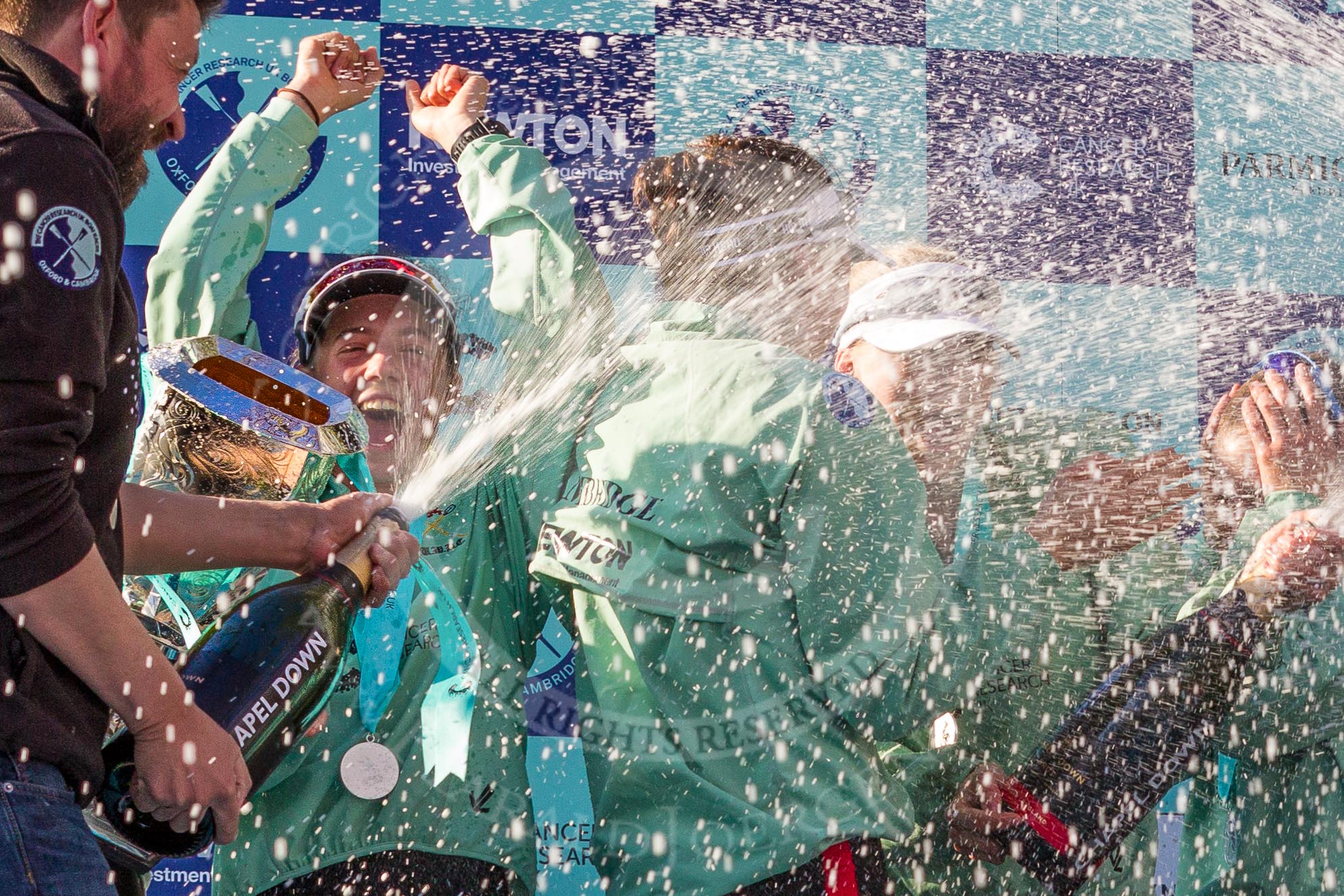 The Boat Race season 2017 -  The Cancer Research Women's Boat Race: CUWBC head coach Rob Barker spraying Champagne at the crew, on his right cox Matthew Holland.
River Thames between Putney Bridge and Mortlake,
London SW15,

United Kingdom,
on 02 April 2017 at 17:13, image #264