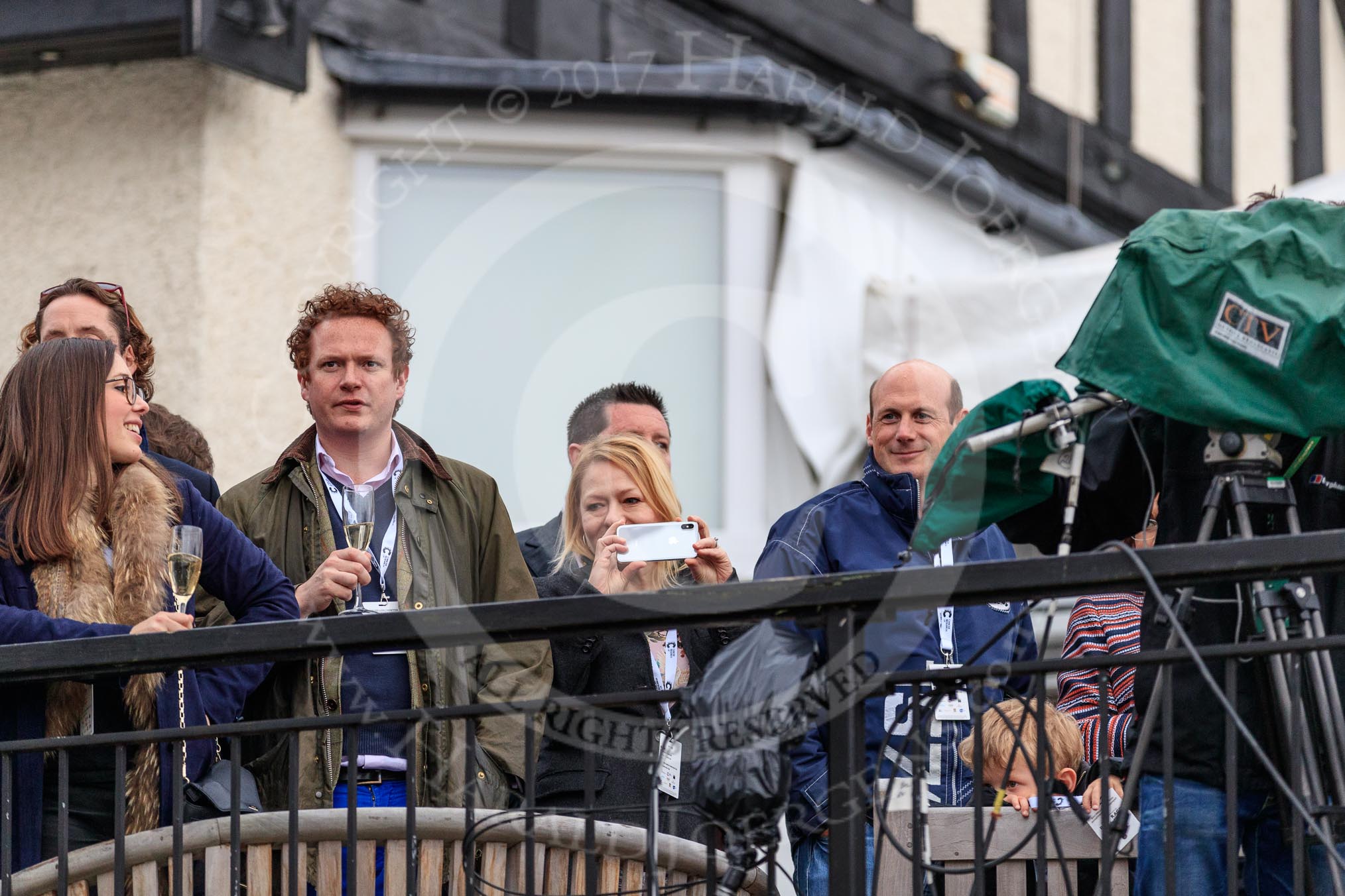 Photo 1803241659171X25157HaraldJoergens The Cancer Research UK Women's Boat Race 2018: Spectators on the balcony of Mortlake Boat Club, waiting for the price giving.
River Thames between Putney Bridge and Mortlake,
London SW15,
United Kingdom,
on 24 March 2018 at 16:59, image #229