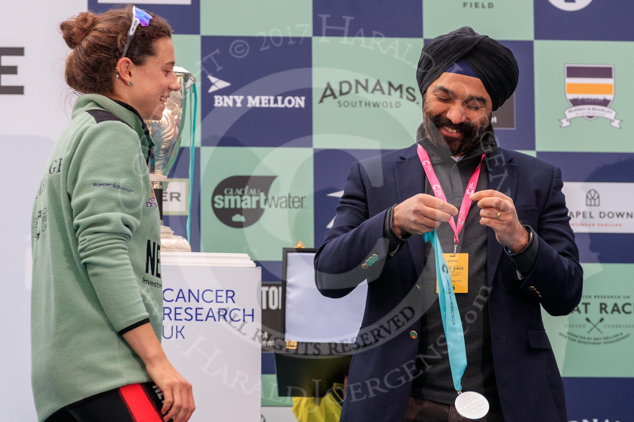 The Cancer Research UK Women's Boat Race 2018: Sir Harpal Kumar, CEO of Cancer Research UK. congratulating Cambridge 2 seat Imogen Grant at the trophy presentation.
River Thames between Putney Bridge and Mortlake,
London SW15,

United Kingdom,
on 24 March 2018 at 17:06, image #252