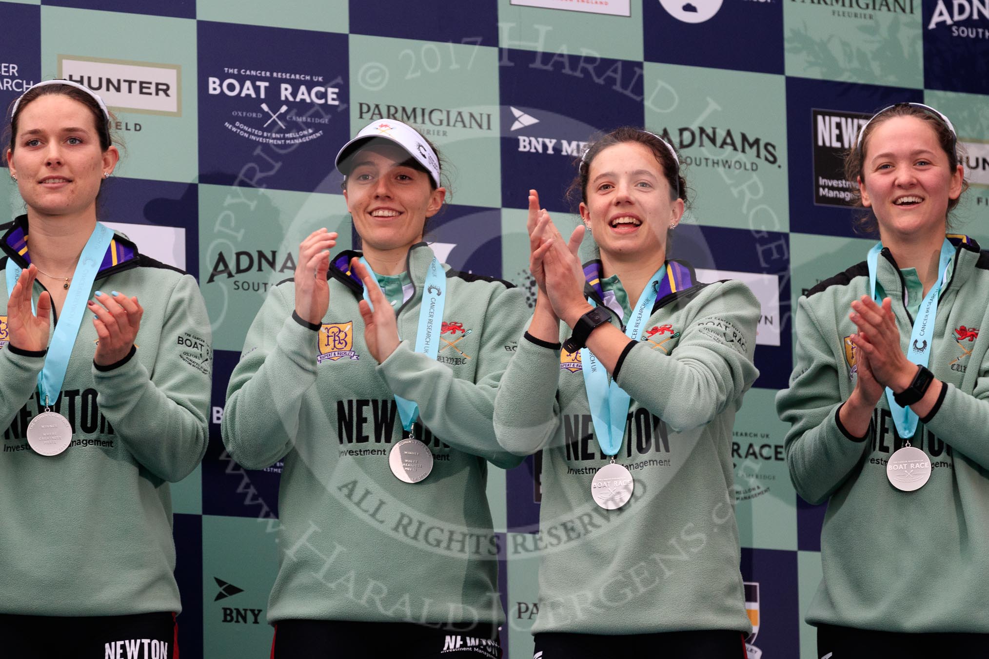 Photo 1803241707371X25354HaraldJoergens The Cancer Research UK Women's Boat Race 2018: Cambridge 4 seat Thea Zabell, 3 seat Kelsey Barolak, 2 seat Imogen Grant, and bow seat Tricia Smith, with her Women's Boat Race medals. on the podium.
River Thames between Putney Bridge and Mortlake,
London SW15,
United Kingdom,
on 24 March 2018 at 17:07, image #265