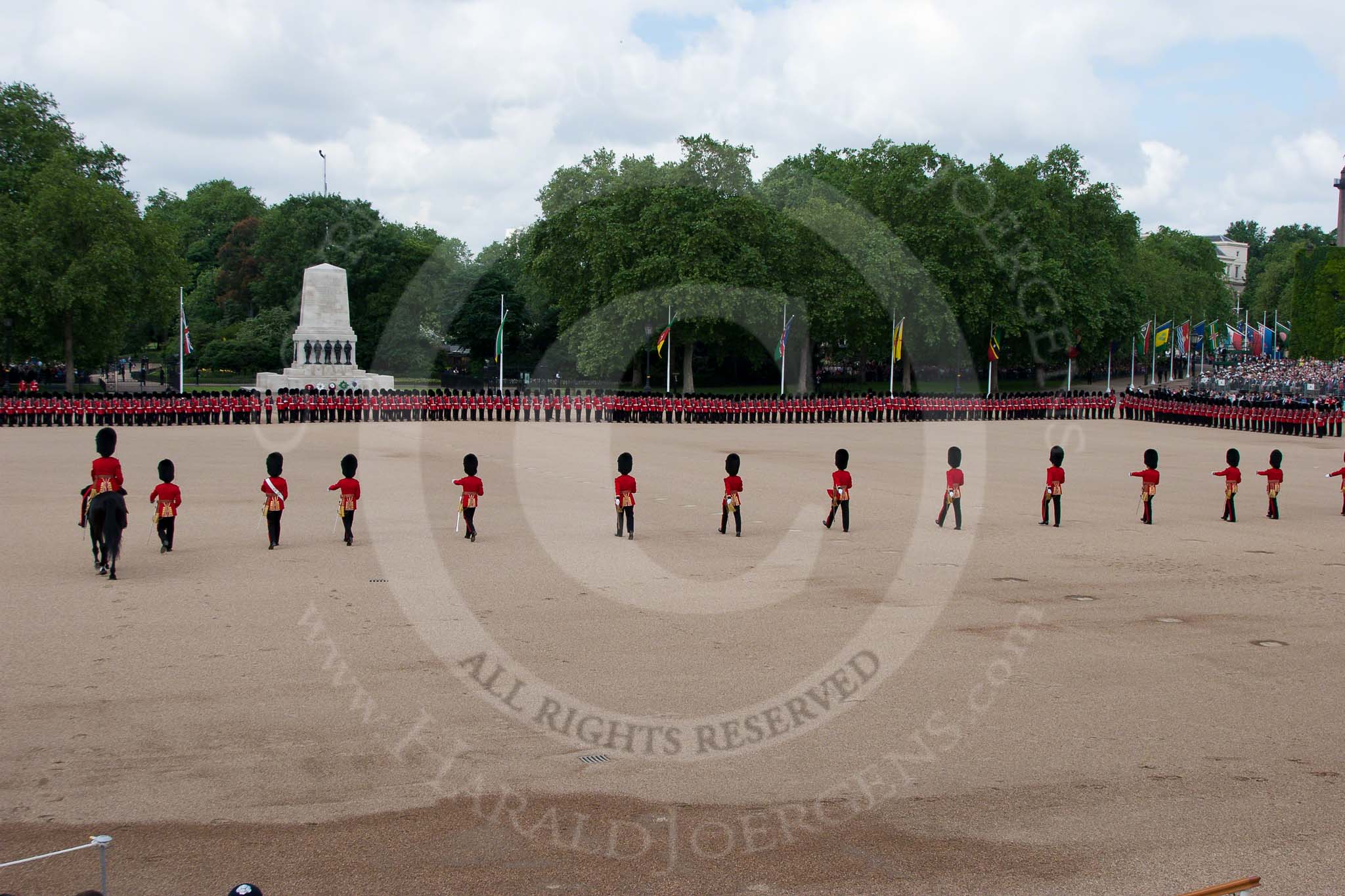 Trooping the Colour 2010: No. 1 to No. 6 Guard are in position for the parade.

The flags are part of 63 flags representing the Commonwealth nations.

Behind the flags spectatots watching from St. James's Park.

On the left the Guards Memorial.

No. 3 Guard, left, (1st Battalion Grenadier Guards) and No. 4 Guard (Nijmegen Company Grenadier Guards) are in position..
Horse Guards Parade, Westminster,
London SW1,
Greater London,
United Kingdom,
on 12 June 2010 at 10:41, image #25
