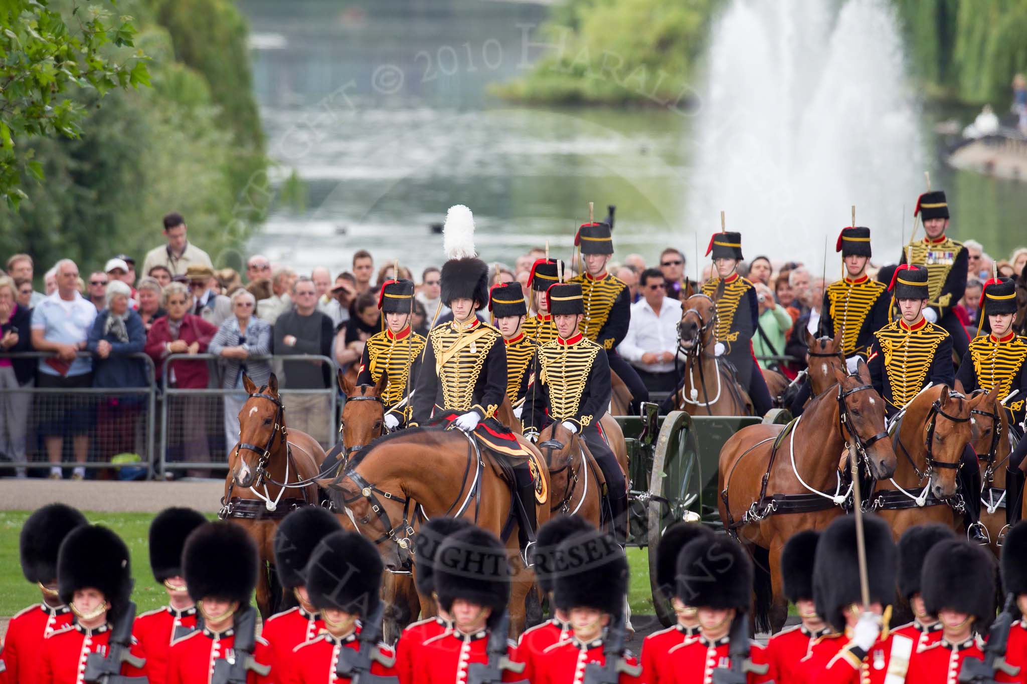 Trooping the Colour 2010: Behind No. 1 Guard,  1st Battalion Grenadier Guards, and in front of spectators watching from St. James's Park, with a lake and fountain in the background, is The King's Troop Royal Horse Artillery, with their horses and 13-pounder state saluting guns..
Horse Guards Parade, Westminster,
London SW1,
Greater London,
United Kingdom,
on 12 June 2010 at 10:42, image #28