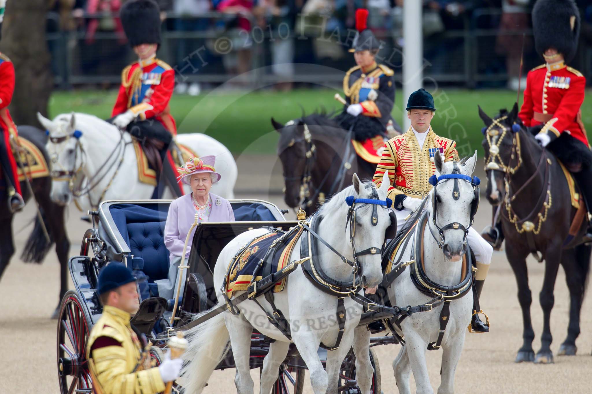 Trooping the Colour 2010: Her Majesty The Queen, sitting in her Ivory Mounted Phaeton,  inspecting the line of soldiers on the parade ground.

Following the carriage the Royal Colonels, Prince Charles (cut off at the very left), the Duke of Kent, and the Princess Royal.

In the background spectators watching from St. James's Park, on the western end of the parade ground, and in the foreground one of the Drum Majors..
Horse Guards Parade, Westminster,
London SW1,
Greater London,
United Kingdom,
on 12 June 2010 at 11:06, image #91