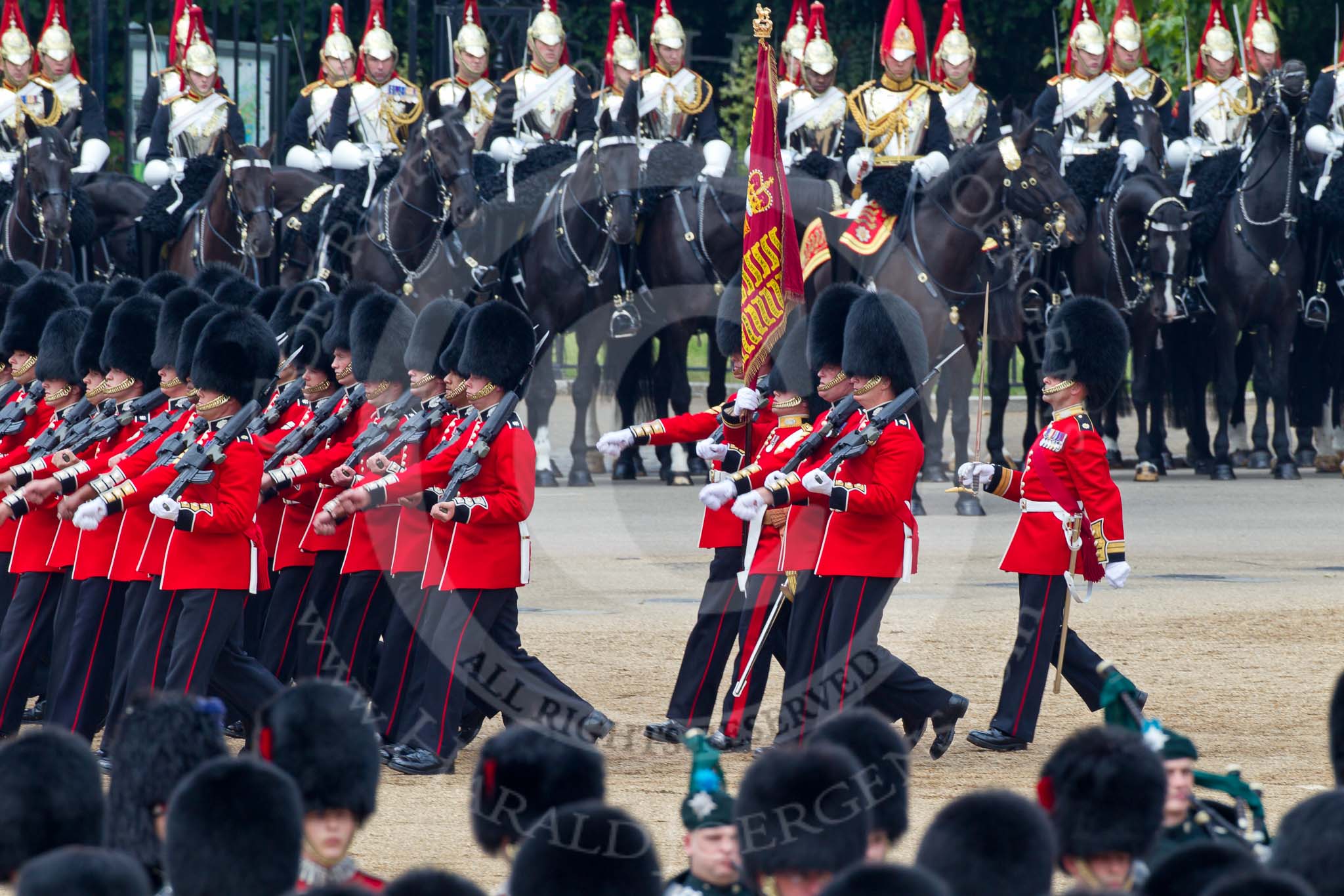 Trooping the Colour 2011: The Escort to the Colour, 1st Battalion Scots Guards, during the March Past in slow time. Carrying the Colour, the Ensign, Tom Ogilvy, on his left Colour Sergeant Chris Millin. In the background the Household Cavalry, here the Blues and Royals..
Horse Guards Parade, Westminster,
London SW1,
Greater London,
United Kingdom,
on 11 June 2011 at 11:50, image #300