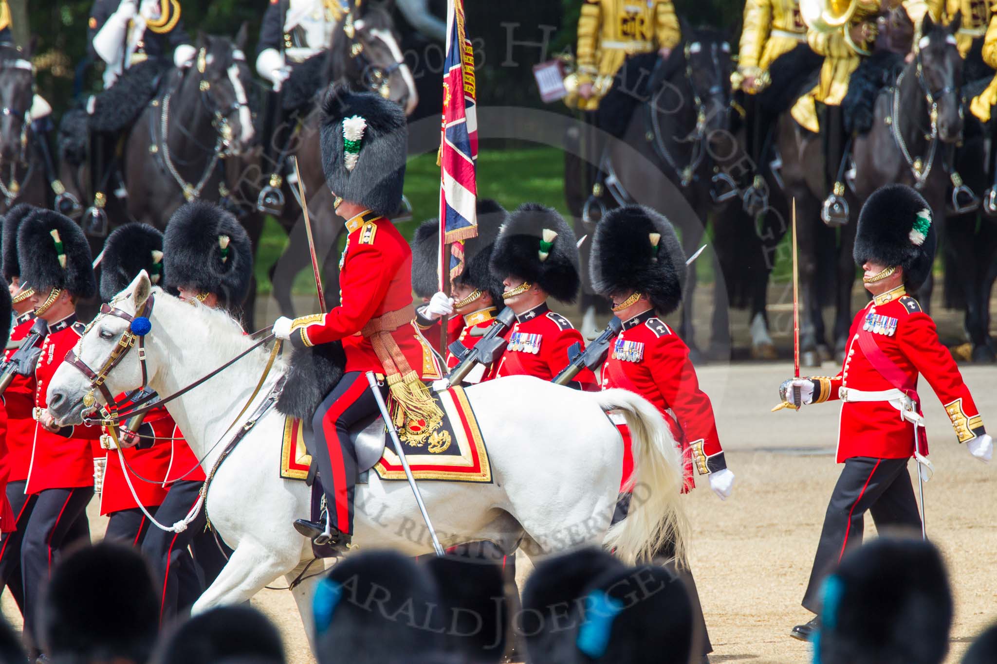 The Colonel's Review 2013: No. 1 Guard (Escort for the Colour),1st Battalion Welsh Guards, at the beginning of the March Past in Quick Time. Behind them the Mounted Bands of the Household Cavalry. The Field Officer appears from the right to return to the head of the march past..
Horse Guards Parade, Westminster,
London SW1,

United Kingdom,
on 08 June 2013 at 11:40, image #675