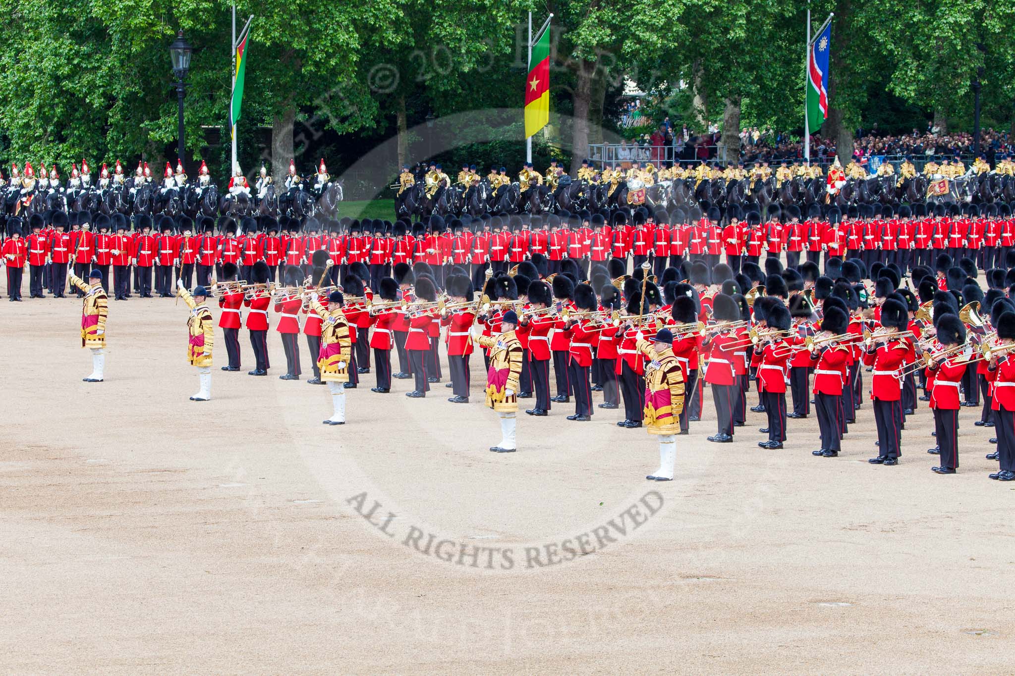 Trooping the Colour 2013: The five Drum Majors leading the Massed Bands during the Massed Bands Troop. Behind the line of guardsmen, with the red plumes, the Household Cavalry (The Blues and Royals) and next to them the Mounted Bands of the Household Cavalry. Image #411, 15 June 2013 11:13 Horse Guards Parade, London, UK