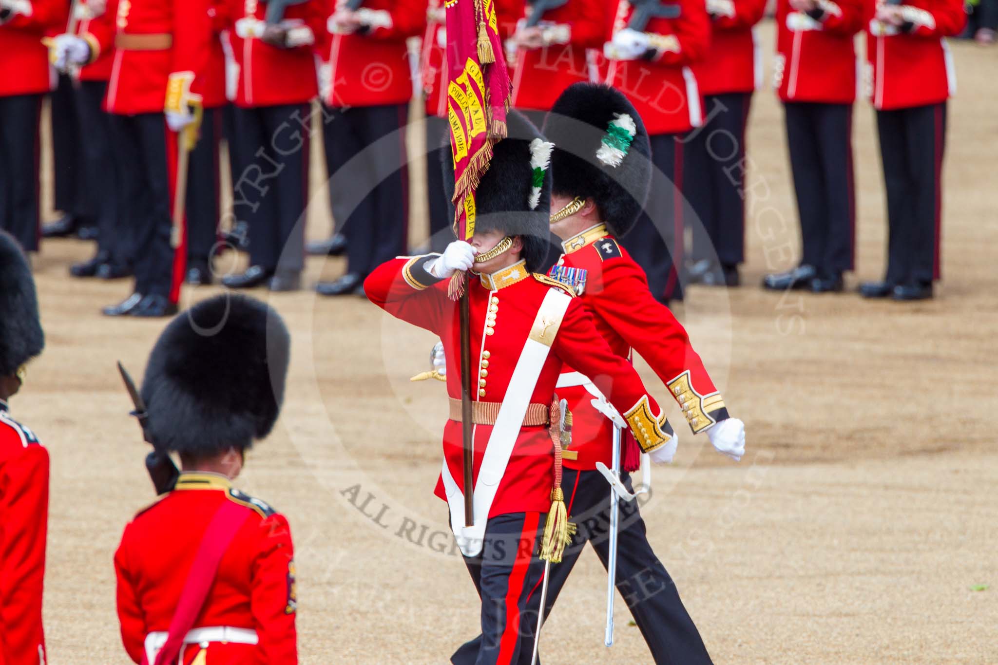 Trooping the Colour 2013: The Ensign, Second Lieutenant Joel Dinwiddle, marches foreward with the Colour, whilst Regimental Sergeant Major, WO1 Martin Topps, Welsh Guards, returns to the Escort to the Colour. Image #470, 15 June 2013 11:22 Horse Guards Parade, London, UK