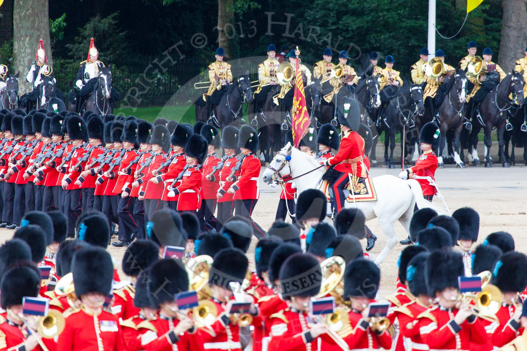 Trooping the Colour 2013: No. 1 Guard (Escort for the Colour),1st Battalion Welsh Guards, at the beginning of the March Past in Quick Time. Behind them the Mounted Bands of the Household Cavalry. The Field Officer appears from the right to return to the head of the march past. Image #579, 15 June 2013 11:42 Horse Guards Parade, London, UK