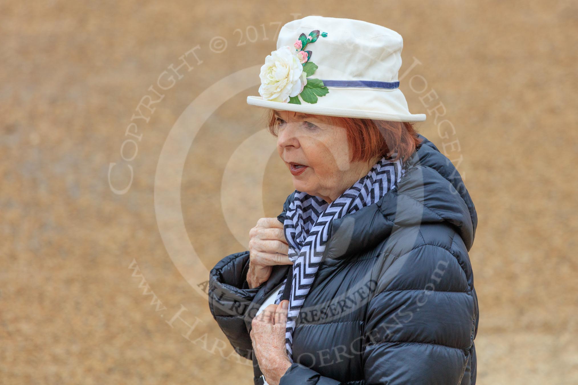Female spectator, wearing a white hat with a large white rose in front, before The Colonel's Review 2018 (final rehearsal for Trooping the Colour, The Queen's Birthday Parade)  at Horse Guards Parade, Westminster, London, 2 June 2018, 09:07.