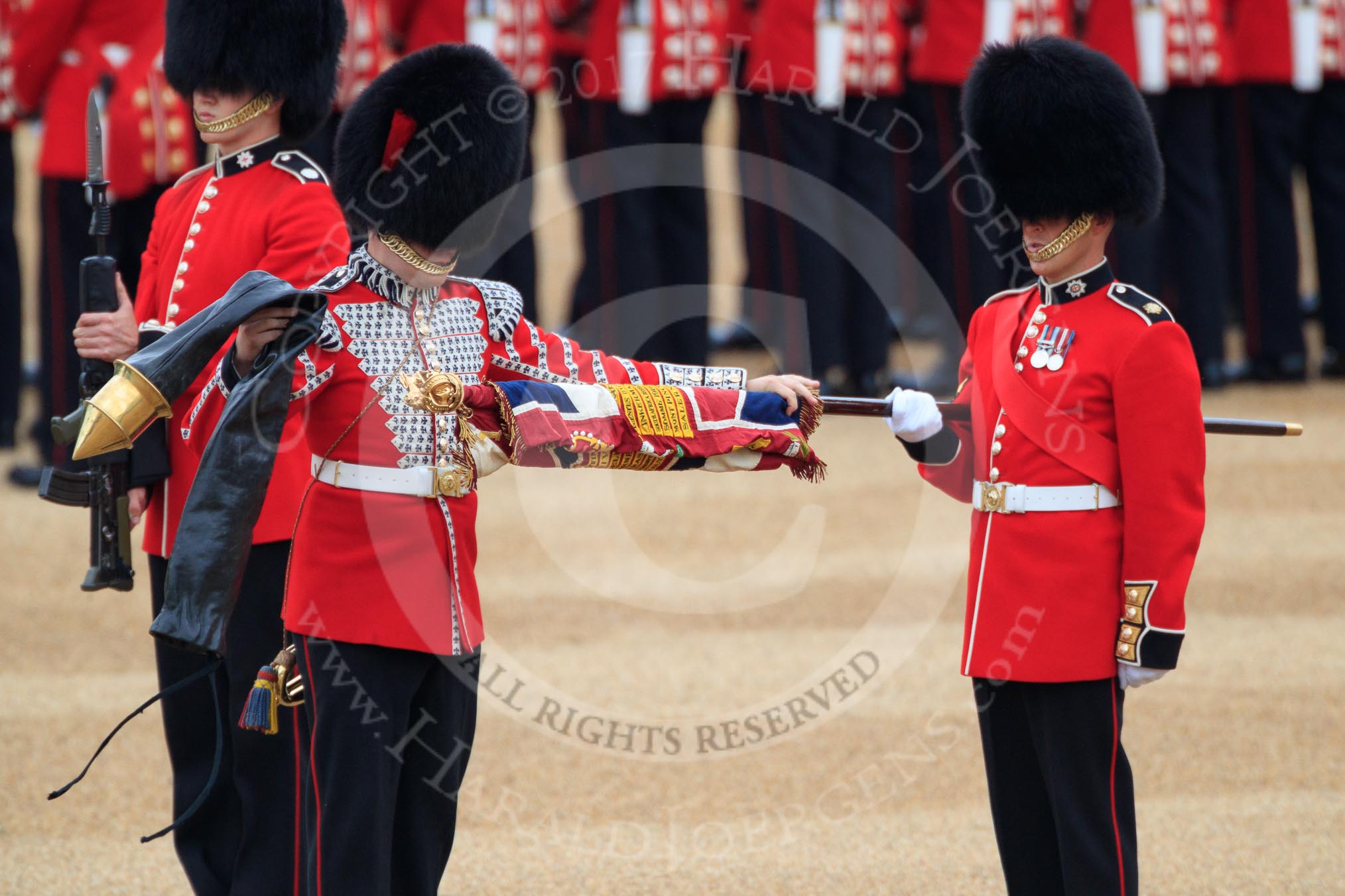Duty Drummer  Sam Orchard uncasing the Colour held by Colour Sergeant Sam McAuley (31), with Colour Sentry Guardsman Jonathon Hughes (26) behind, during The Colonel's Review 2018 (final rehearsal for Trooping the Colour, The Queen's Birthday Parade)  at Horse Guards Parade, Westminster, London, 2 June 2018, 10:33.