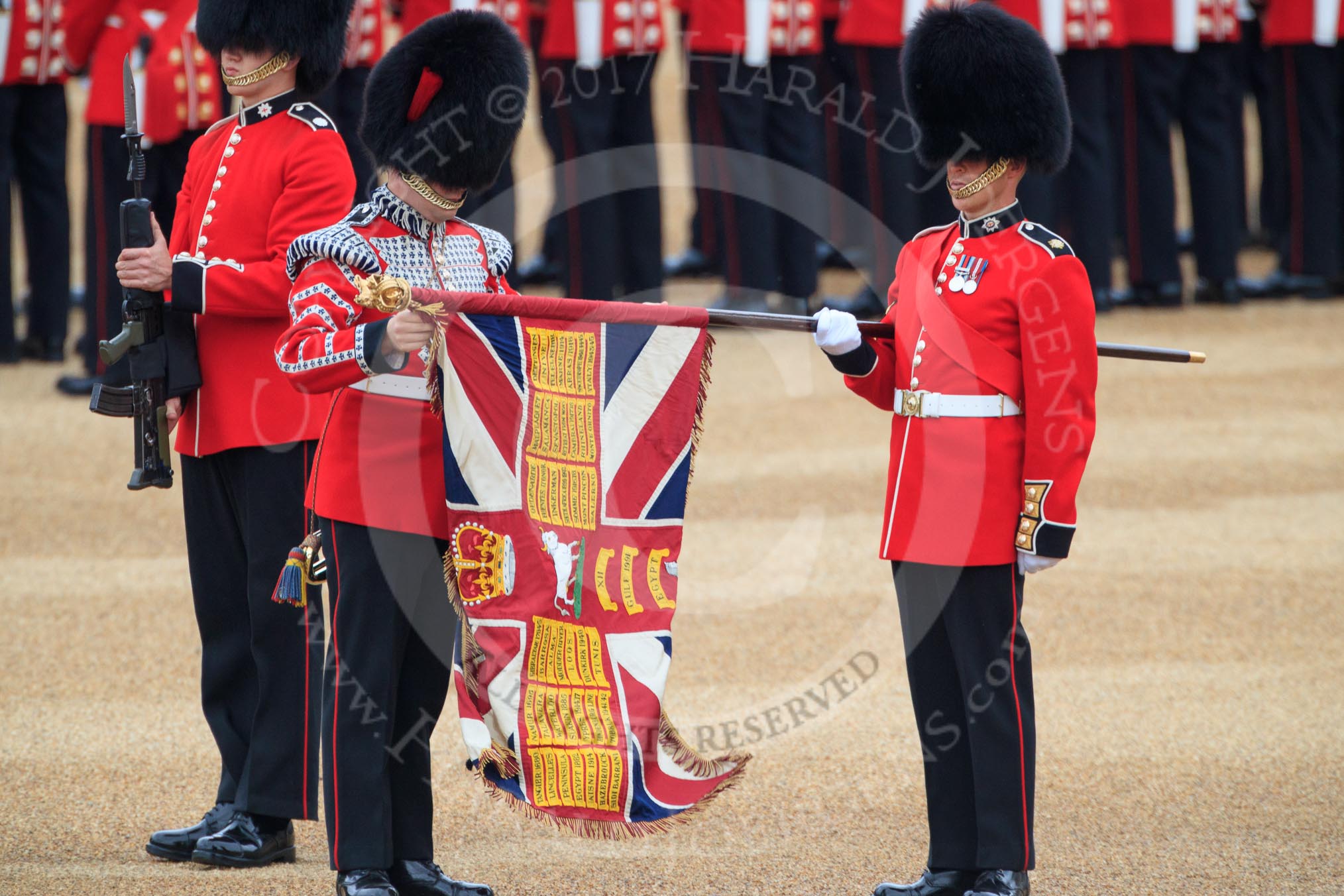 Duty Drummer  Sam Orchard uncasing the Colour held by Colour Sergeant Sam McAuley (31), with Colour Sentry Guardsman Jonathon Hughes (26) behind, during The Colonel's Review 2018 (final rehearsal for Trooping the Colour, The Queen's Birthday Parade)  at Horse Guards Parade, Westminster, London, 2 June 2018, 10:33.