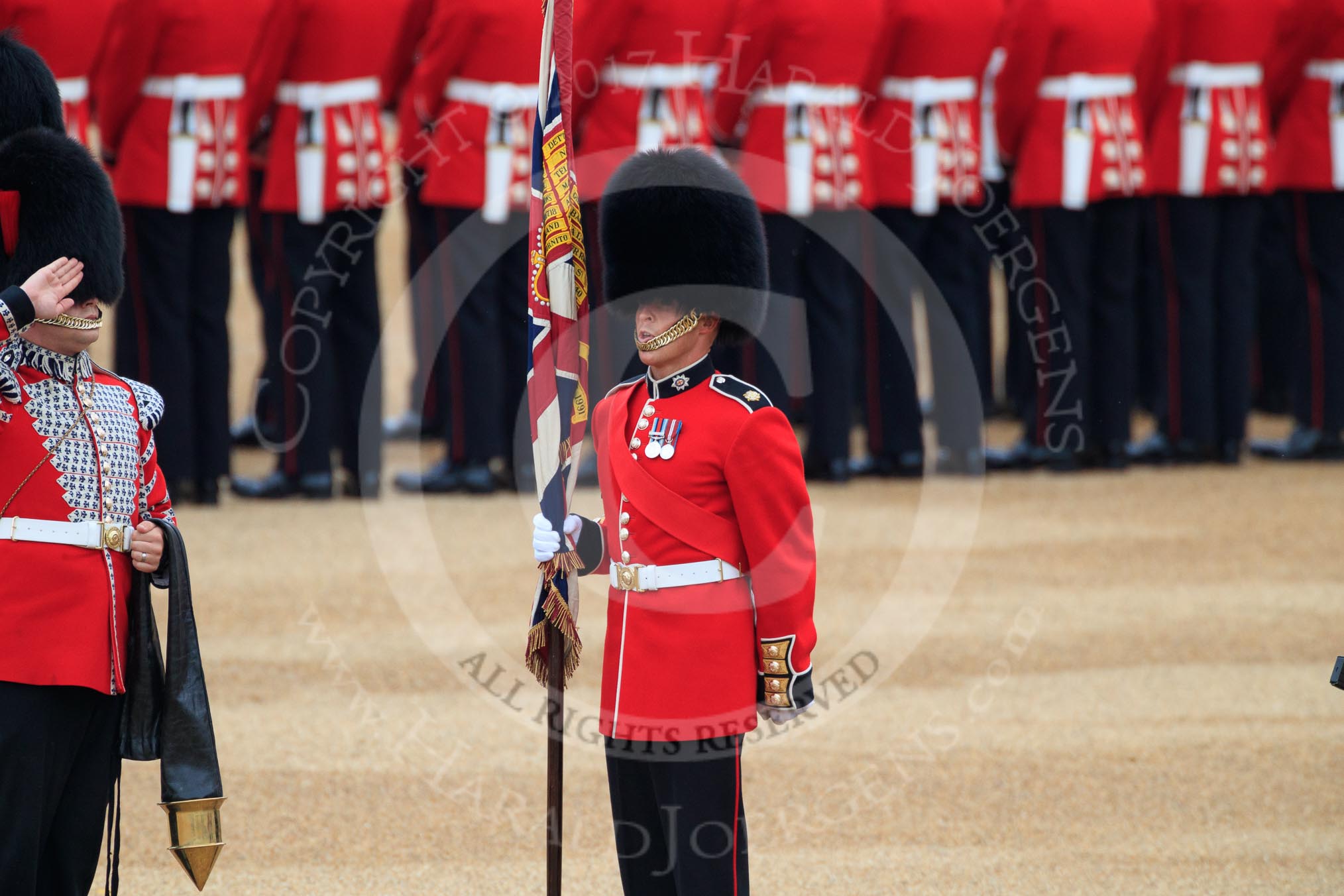 Colour Sergeant Sam McAuley (31) holding the uncased Colour, with Duty Drummer  Sam Orchard saluting, during The Colonel's Review 2018 (final rehearsal for Trooping the Colour, The Queen's Birthday Parade)  at Horse Guards Parade, Westminster, London, 2 June 2018, 10:33.