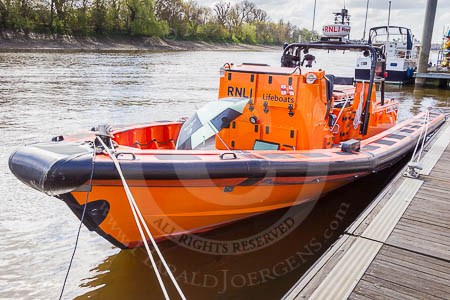 RNLI lifeboat E09 during the photography work at Chiswick Pier, London. The photographer's workplace is on the front deck, shielded against the low sun by a Boat Race umbrella