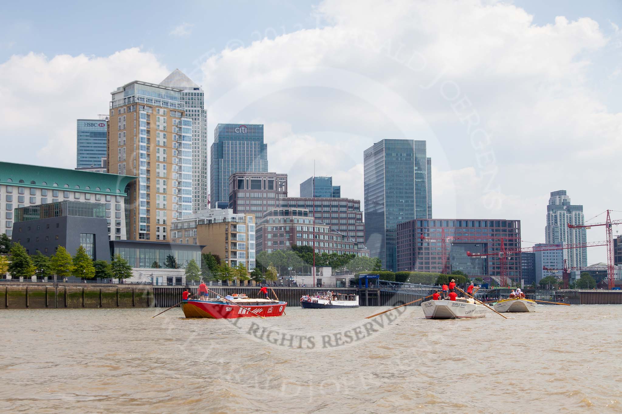 TOW River Thames Barge Driving Race 2013: Barge "Jane", by the RMT Union, followed by barge"Shell Bay" by South Dock Marina, and barge "Hoppy", by GPS Fabrication, in front of the skyscrapers at Canary Wharf..
River Thames between Greenwich and Westminster,
London,

United Kingdom,
on 13 July 2013 at 13:16, image #305