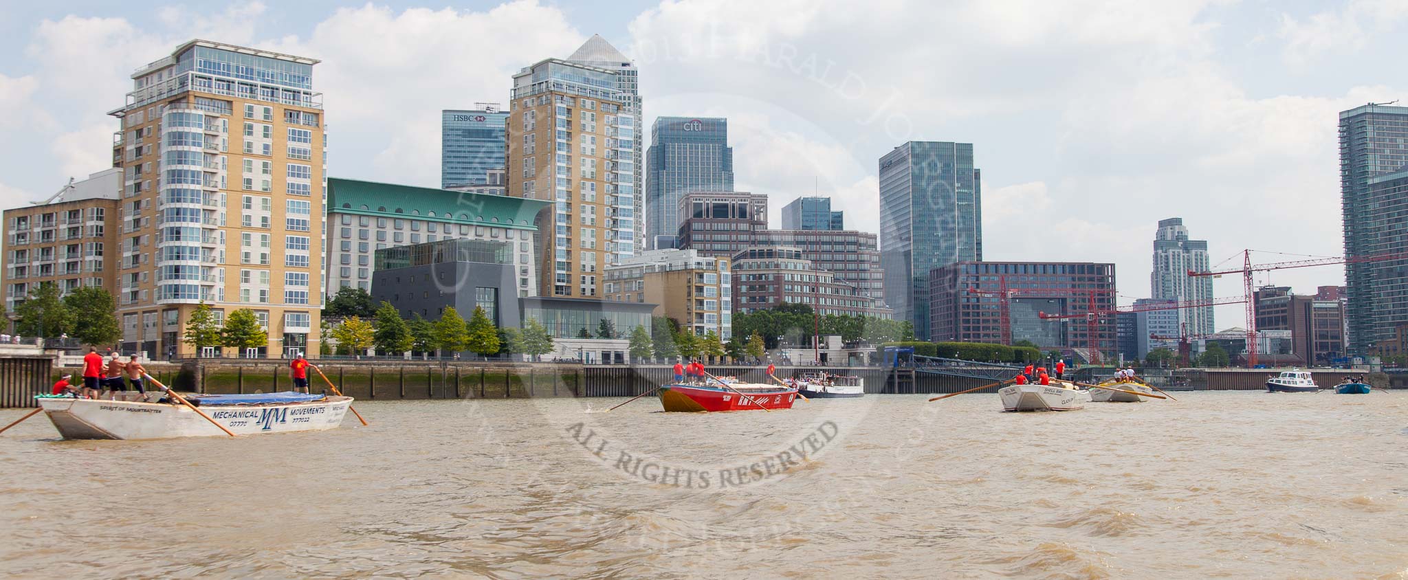 TOW River Thames Barge Driving Race 2013: Barge "Spirit of Mountabatten", by Mechanical Movements and Enabling Services Ltd, followed by "Jane", by the RMT Union, barge"Shell Bay" by South Dock Marina, and barge "Hoppy", by GPS Fabrication, in front of the skyscrapers at Canary Wharf..
River Thames between Greenwich and Westminster,
London,

United Kingdom,
on 13 July 2013 at 13:17, image #307