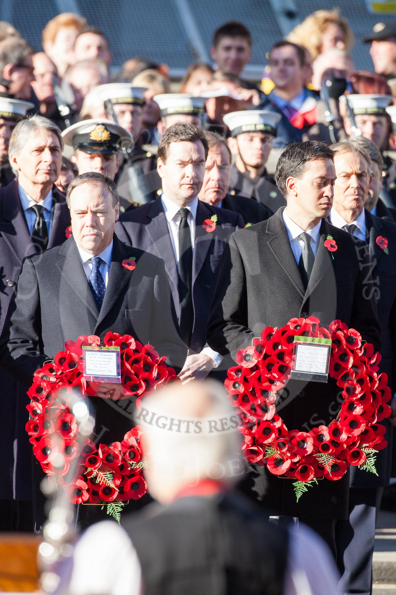 Nigel Dodds as Leader of the Democratic Unionist Party, and Ed Miliband as Leader of the Opposition. Behind Philip Hammond as Defence Secretary, George Osborne as Chancellor of the Exchequer and Toni Blair as former Prime Minister.