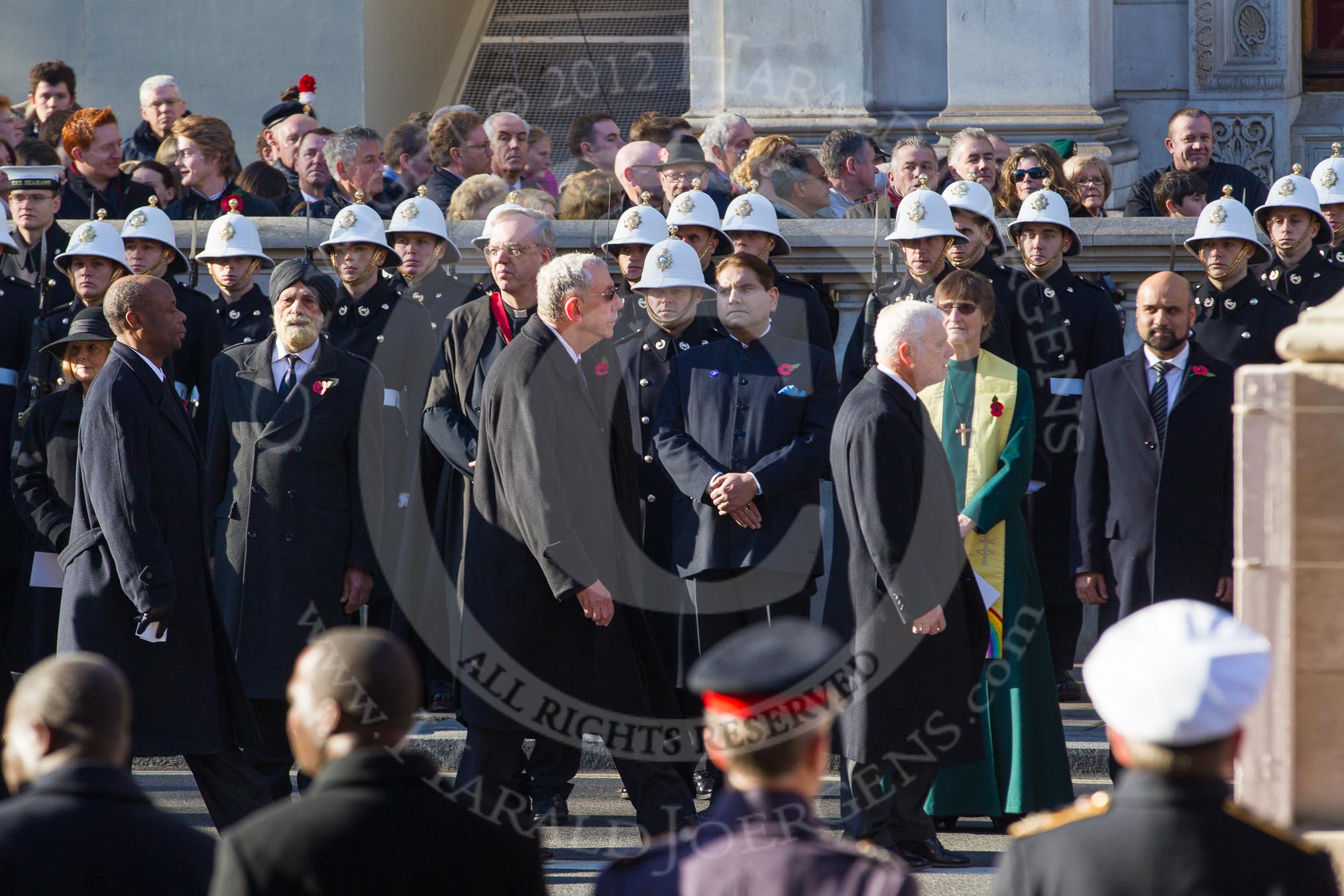 The High Commissioners are leaving Whitehall towards the Foreign- and Commonwealth Office building.  Behind them, and in front of the Royal Marines, the representatives of the faith communities.