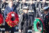 Commander Anne Sullivan, Royal Navy, handing, as Equerry, the wreath to HRH The Princess Royal. In the background the Prime Minister, David Cameron.