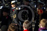 The choir boys and the golden cross with the red poppies, behind, and out of focus, HM The Queen and members of the Royal Family