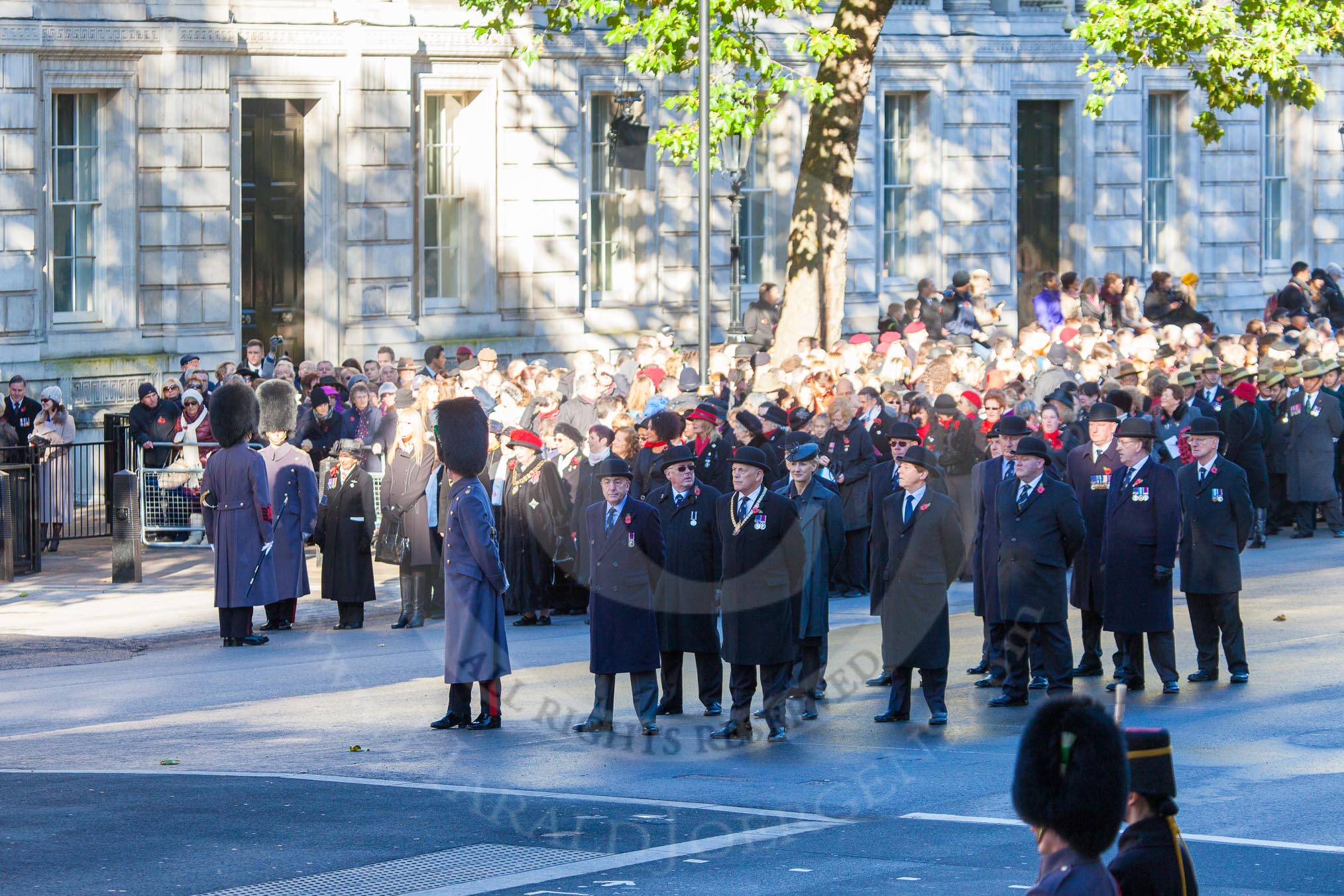 Remembrance Sunday Cenotaph March Past 2013: Whitehall at 10:10am: The build-up for the March Past. Column D, led by the War Widows Association, followed by the British Gurkha Welfare Society..
Press stand opposite the Foreign Office building, Whitehall, London SW1,
London,
Greater London,
United Kingdom,
on 10 November 2013 at 10:10, image #1