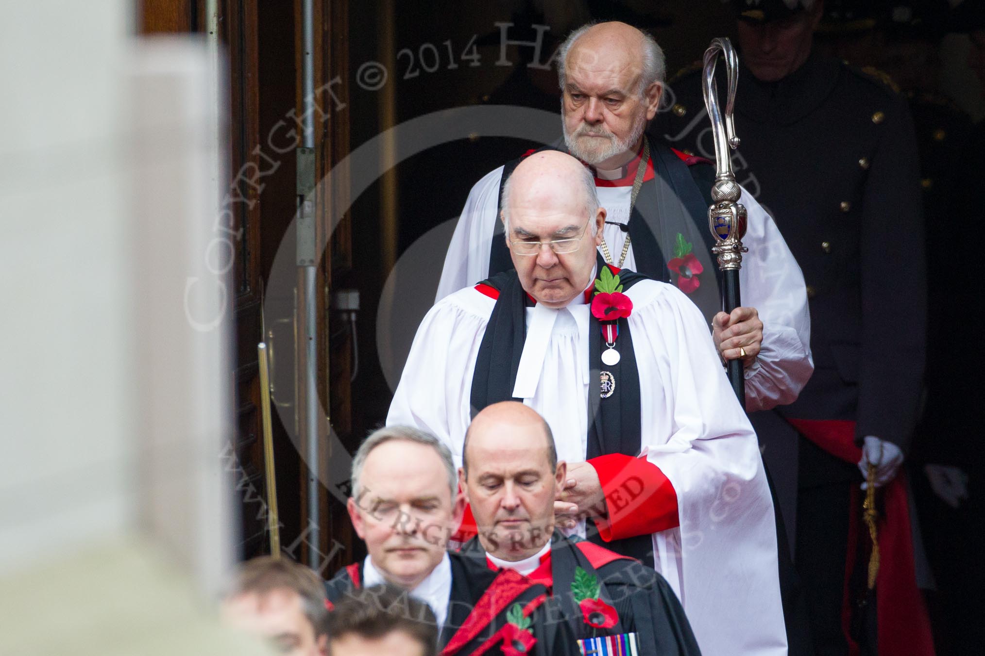 Remembrance Sunday at the Cenotaph in London 2014: The Sub-Dean of Her Majesty’s Chapels Royal, the Reverend Prebendary William Scott, leaving the Commonwealth- and Foreign Office, followed by the Bishop of London.
Press stand opposite the Foreign Office building, Whitehall, London SW1,
London,
Greater London,
United Kingdom,
on 09 November 2014 at 10:53, image #100