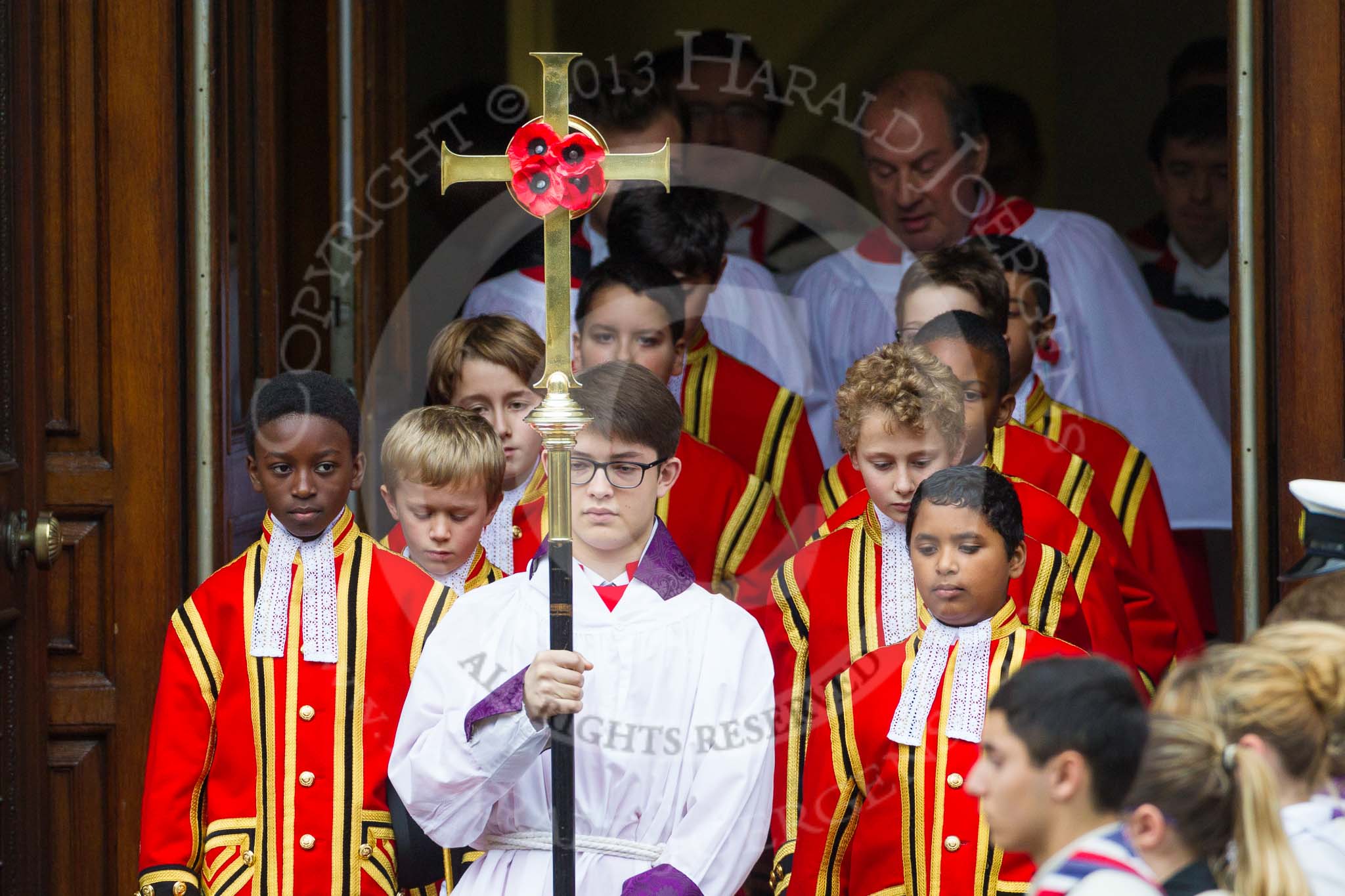 Remembrance Sunday at the Cenotaph 2015: The choir, led by the Cross Bearer, Jason Panagiotopoulos, is emerging from the Foreign- and Commonwealth Office Building. Behind them the 6 Gentlemen-in-Ordinary. Image #74, 08 November 2015 10:53 Whitehall, London, UK