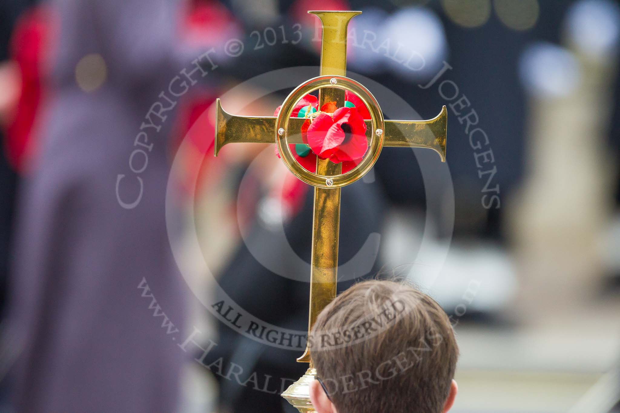Remembrance Sunday at the Cenotaph 2015: Close-up of the Cross, with HM The Queen out of focus behind. Image #137, 08 November 2015 10:59 Whitehall, London, UK