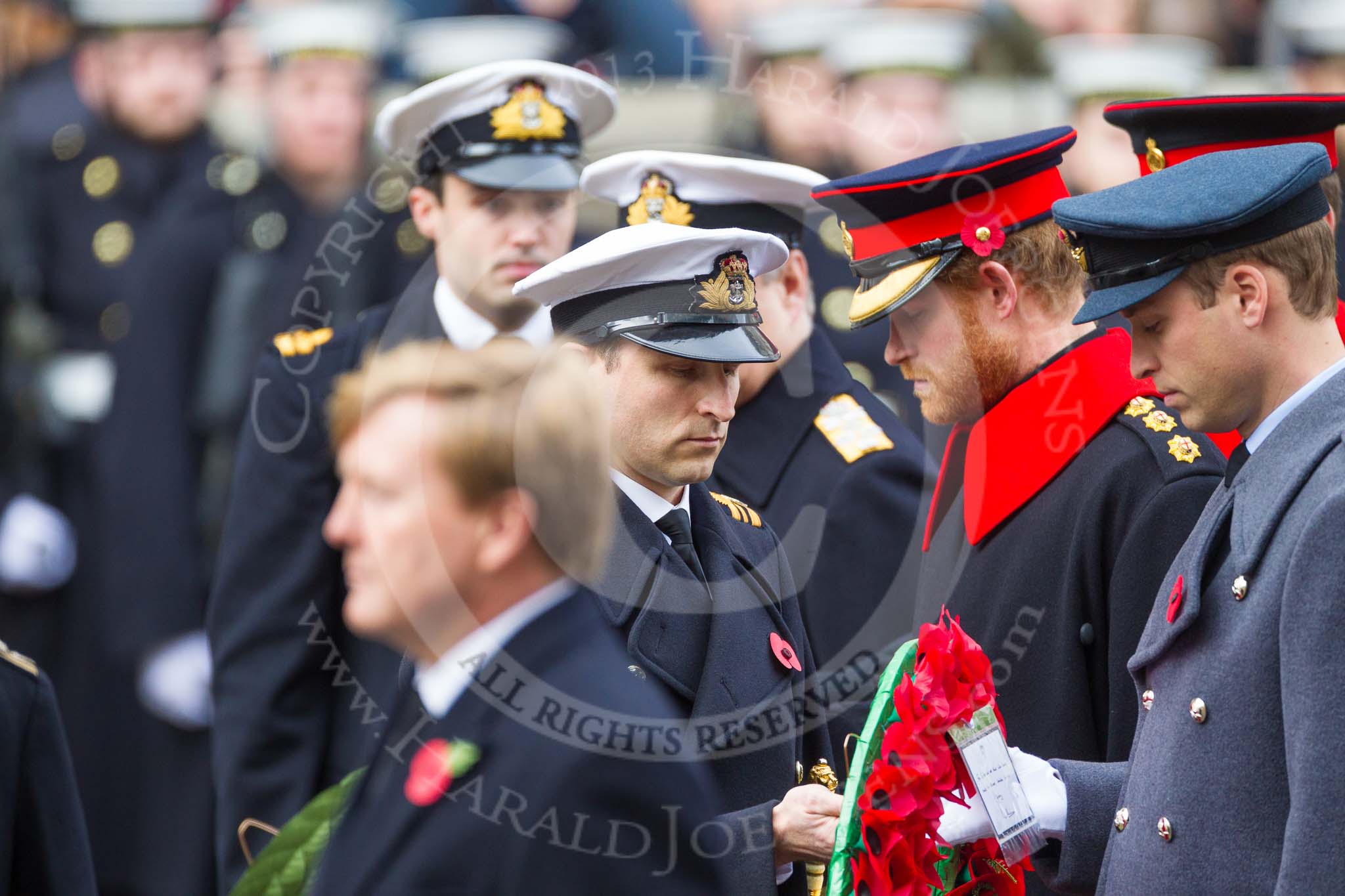 Remembrance Sunday at the Cenotaph 2015: The Equerry to HRH The Duke of Cambridge,  Lieutenant  Commander  James  Benbow, Royal Navy, handing over the wreath to Prince William. Behind them, Captain  Edward  Lane  Fox, Equerry to HRH Prince Henry of Wales, is handing over the wreath to Prince Harry. Image #190, 08 November 2015 11:05 Whitehall, London, UK