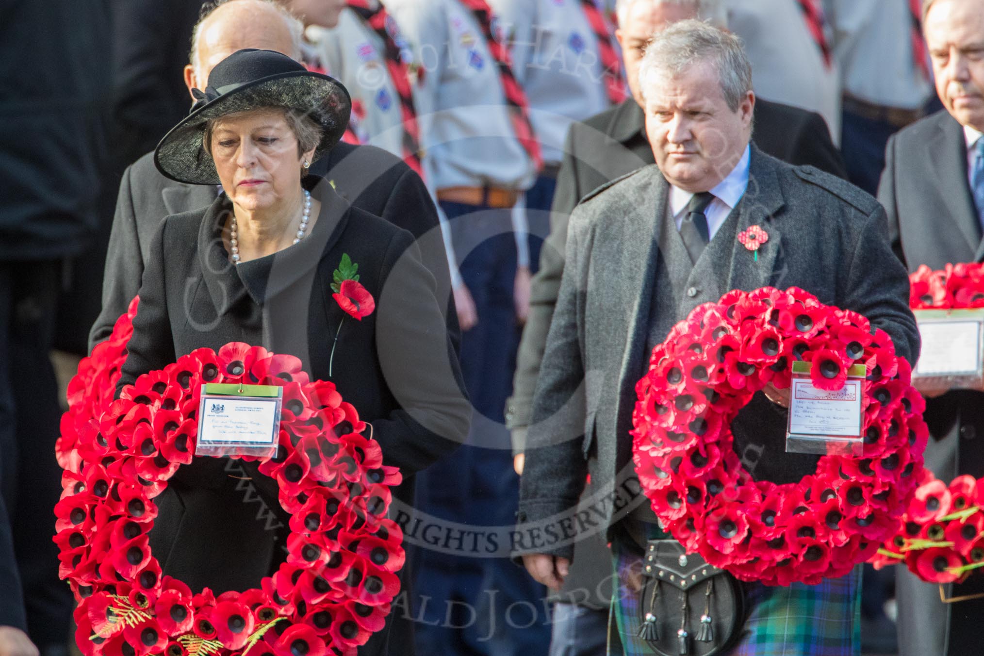 The Rt Hon Theresa May MP, Prime Minister, on behalf of the Government, and Mr Ian Blackford MP (the Westminster Scottish National Party Leader on the behalf of the SNP/the Plaid Cymru Parliamentary Group)  leaving the Foreign and Commonwealth Office with their wreaths during Remembrance Sunday Cenotaph Ceremony 2018 at Horse Guards Parade, Westminster, London, 11 November 2018, 10:55.