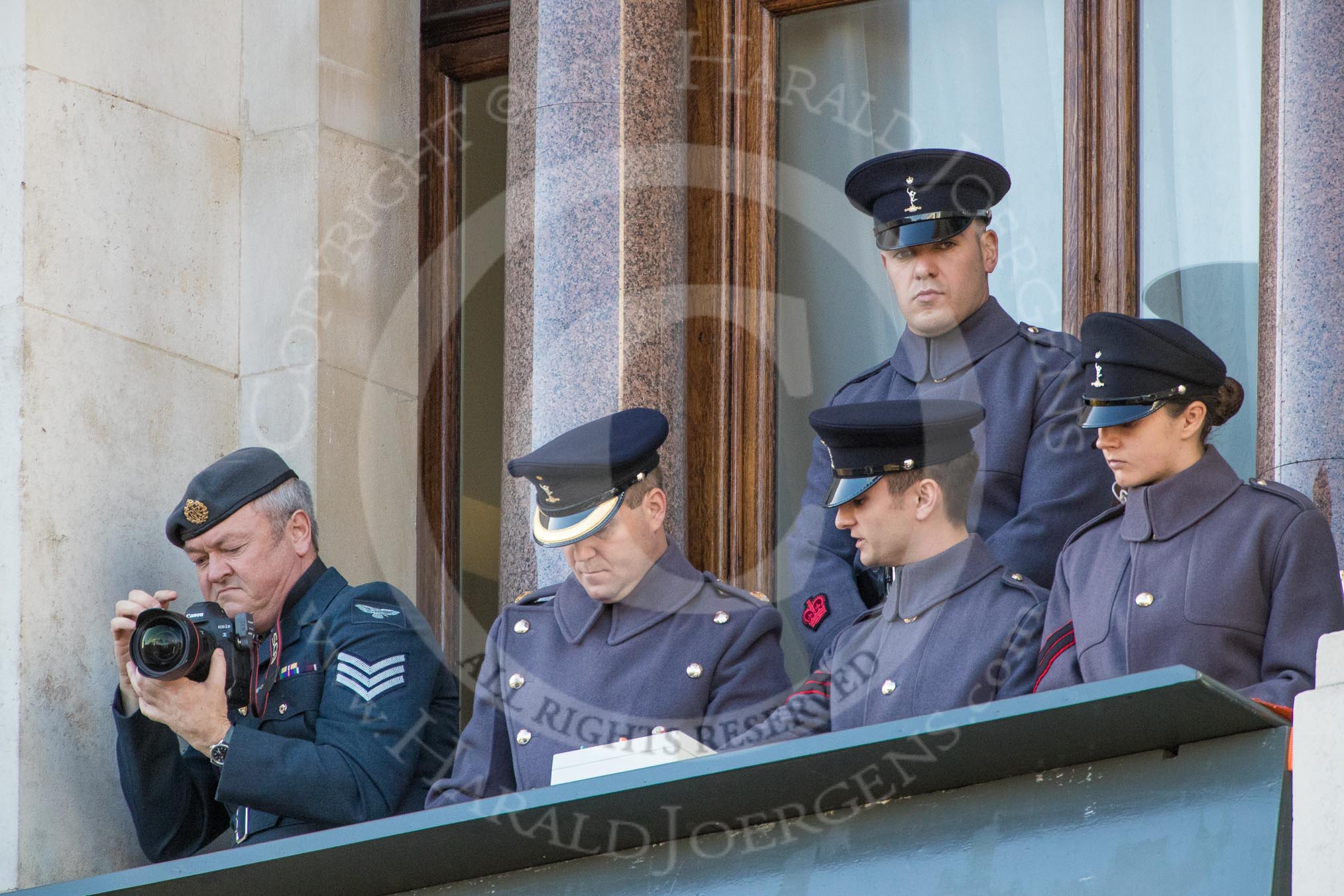 A team of army officers controlling the event's music (?), and an army photographer, on a top floor window of teh Foreign and Commonwealth Office during the Remembrance Sunday Cenotaph Ceremony 2018 at Horse Guards Parade, Westminster, London, 11 November 2018, 11:19.