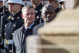 Can't identify the gentleman on the left. On the right the The High Commissioner of Uganda, Julius Peter Moto, during Remembrance Sunday Cenotaph Ceremony 2018 at Horse Guards Parade, Westminster, London, 11 November 2018, 11:04.