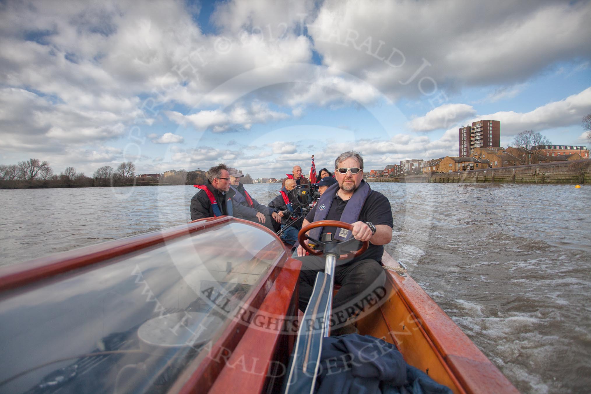 The Boat Race season 2012 - fixture CUBC vs Leander: The press launch, carrying photographers and television crews, returning to base after the CUBC vs Leander fixture. The Mile Post is on the left, and Surrey Bend in the background..
River Thames between Putney and Molesey,
London,
Greater London,
United Kingdom,
on 10 March 2012 at 14:31, image #153