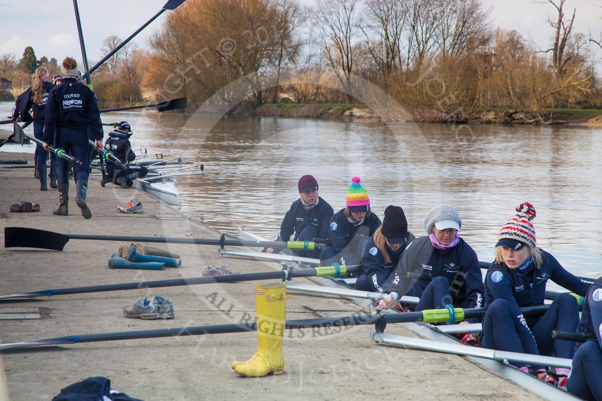 The Boat Race season 2013 - OUWBC training: The OUWBC Blue Boat squad getting ready at Fleming Boathouse - bow Mariann Novak, Alice Carrington-Windo, Mary Foord-Weston, Jo Lee, Amy Varney, Harriet Keane, Anastasia Chitty, stroke Maxie Scheske, and cox Katie Apfelbaum. In the background the Osiris crew..
Fleming Boathouse,
Wallingford,
Oxfordshire,
United Kingdom,
on 13 March 2013 at 16:51, image #28
