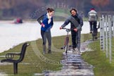 The Boat Race season 2013 - CUWBC training: OULRC Head Coach Bodo Schulenburg and Assistant Coach Tina Thomas. In the background, cycling in the opposite direction, CUWBC head coach Rob Baker..
River Thames near Remenham,
Henley-on-Thames,
Oxfordshire,
United Kingdom,
on 19 March 2013 at 16:33, image #174